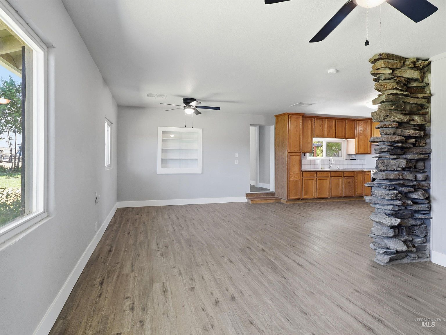 Open-concept living and kitchen area with stone pillar
