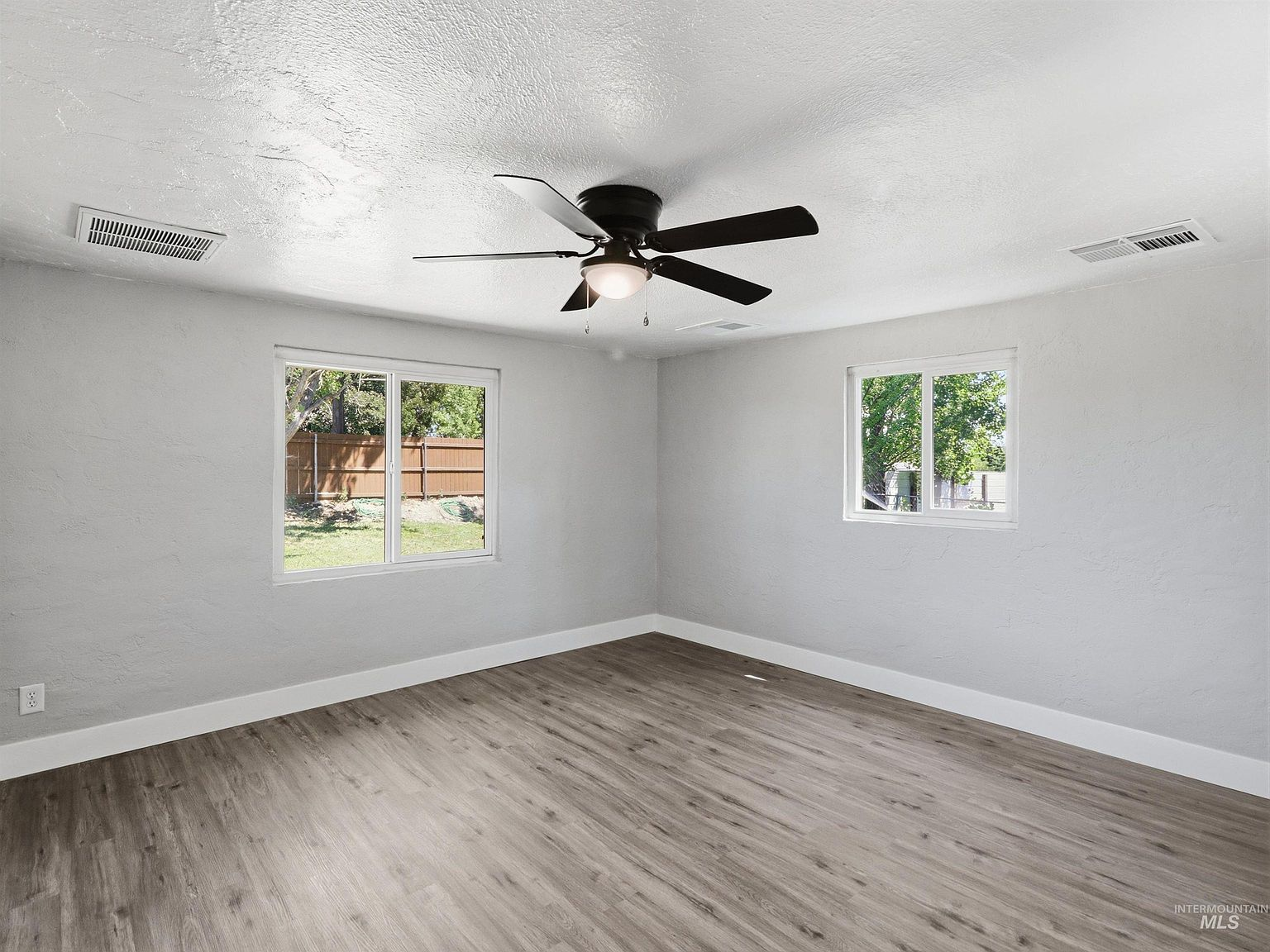 Vacant bedroom with grey walls and dual windows