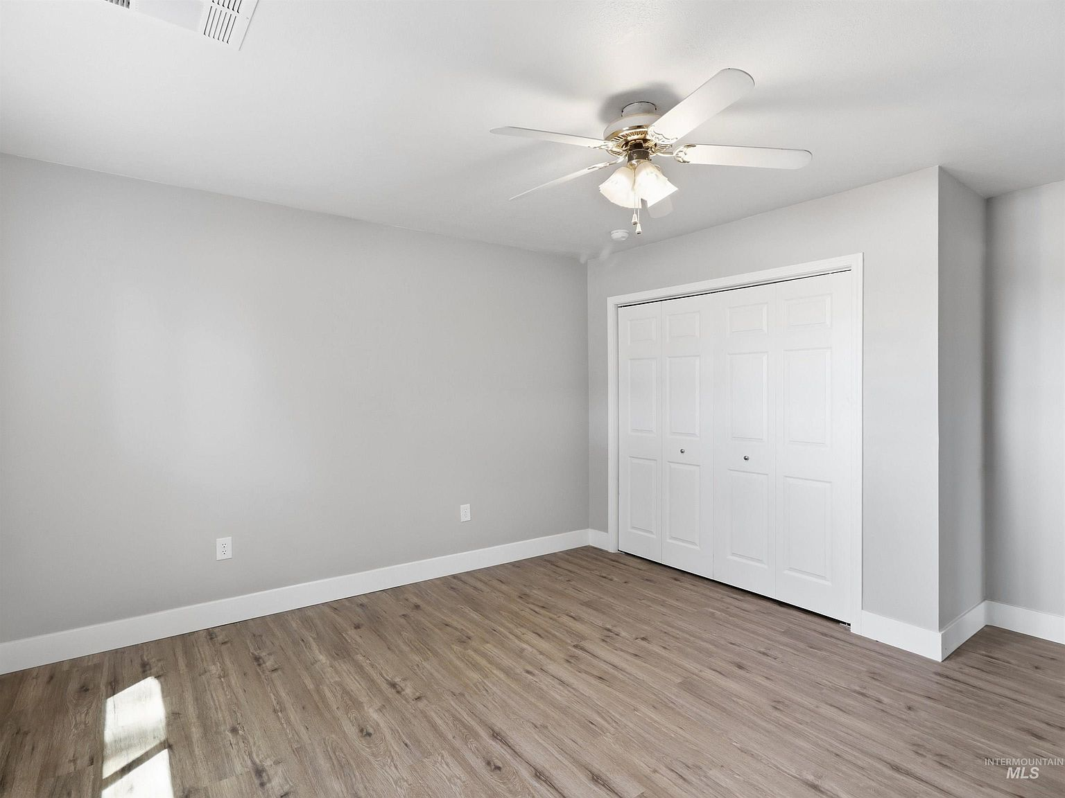 Secondary bedroom with LVP flooring and bifold closet doors