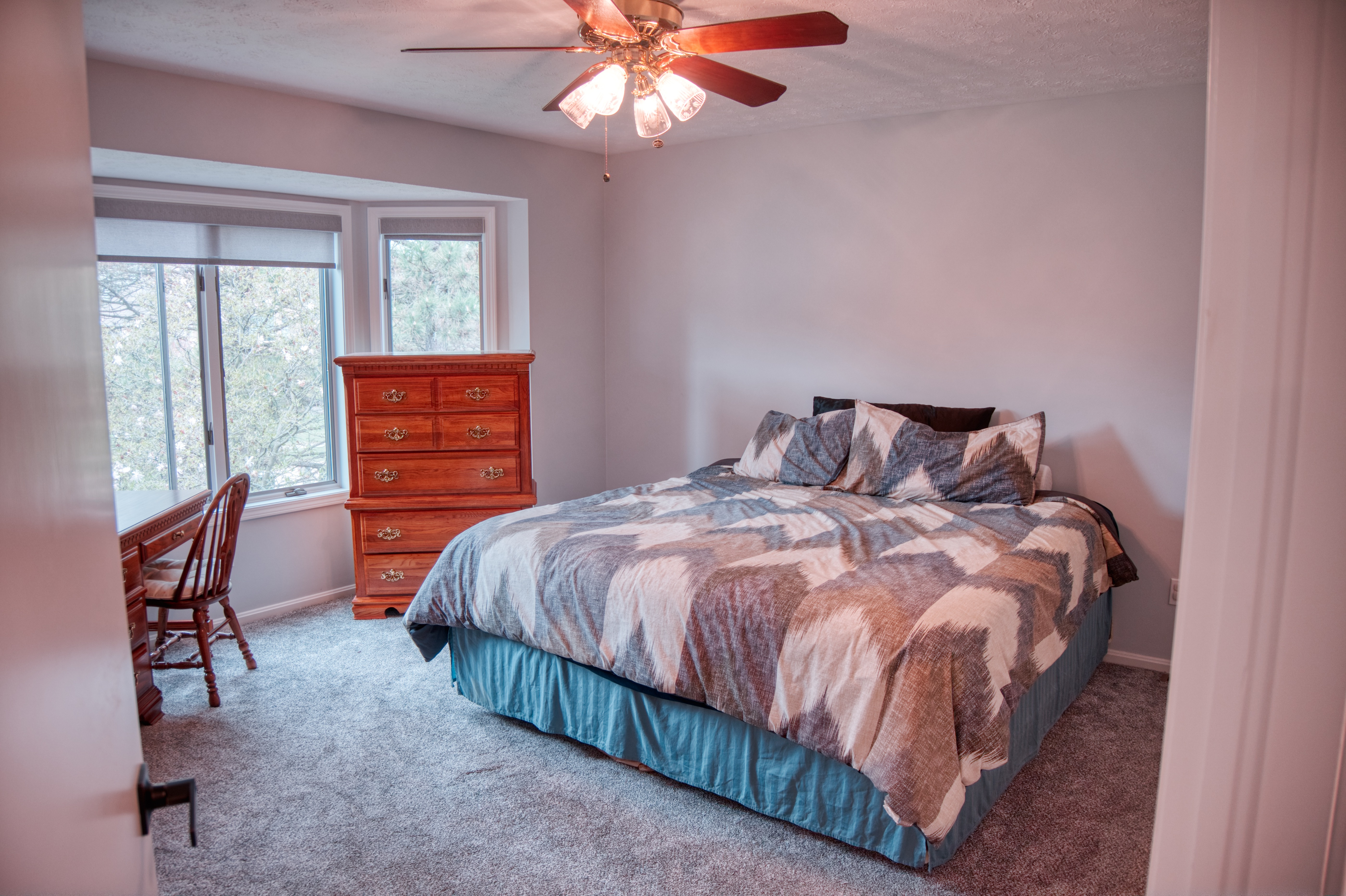 Master bedroom suite view from doorway with bay windows and carpeted floors