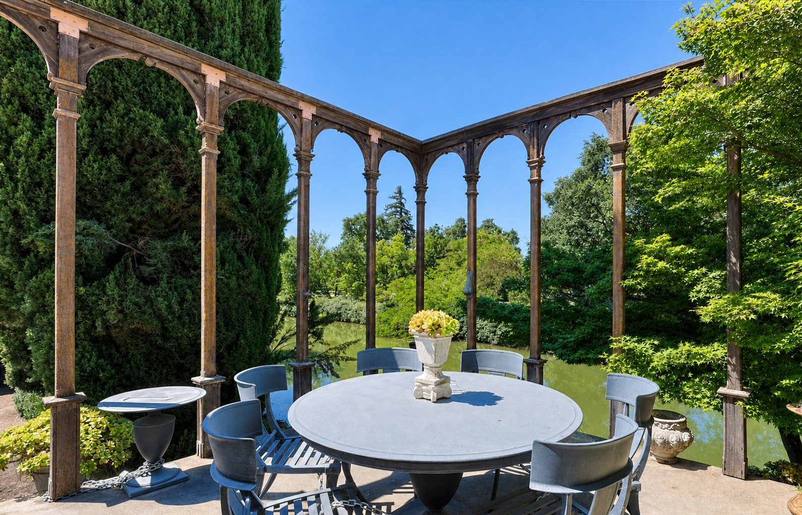 Creekside patio under a pergola overlooking Bear Creek