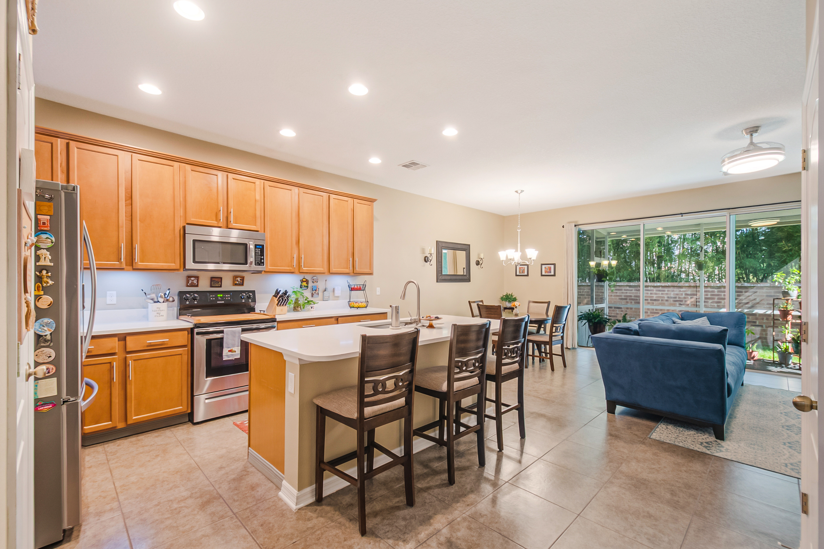Open-concept kitchen and living area with quartz countertops and stainless steel appliances
