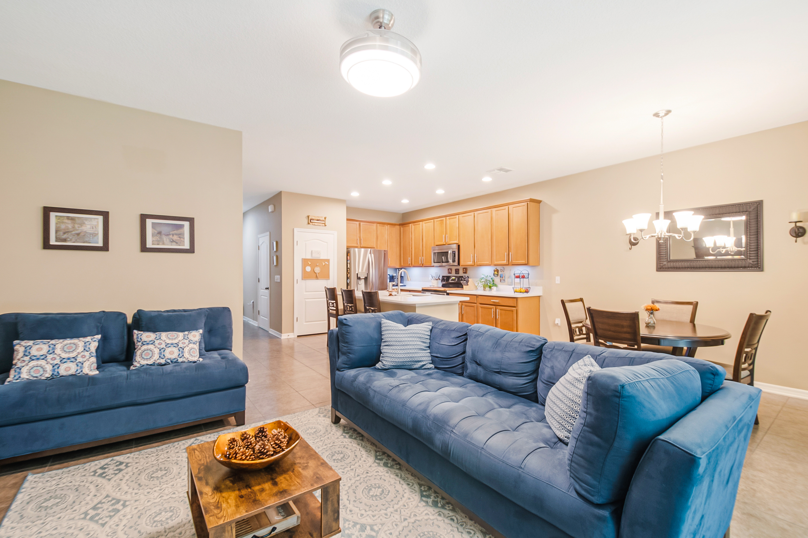 Open-concept shot showing living, dining, and kitchen areas with neutral tones