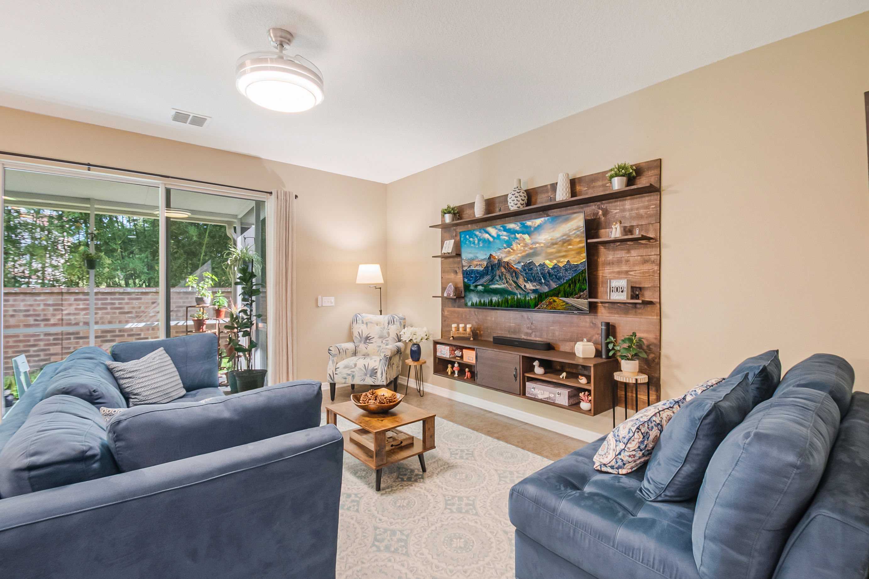Living room with wood-slat accent wall and natural light from sliding patio doors