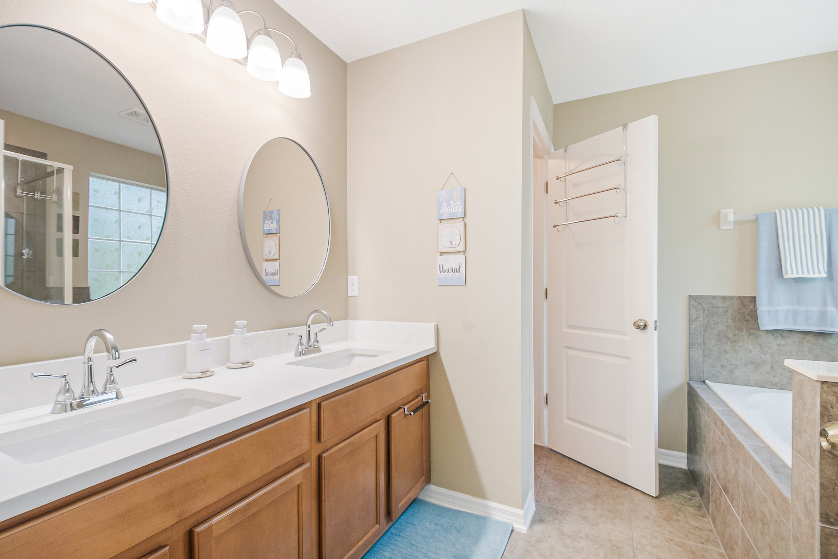 Primary bathroom with double vanity and tub area