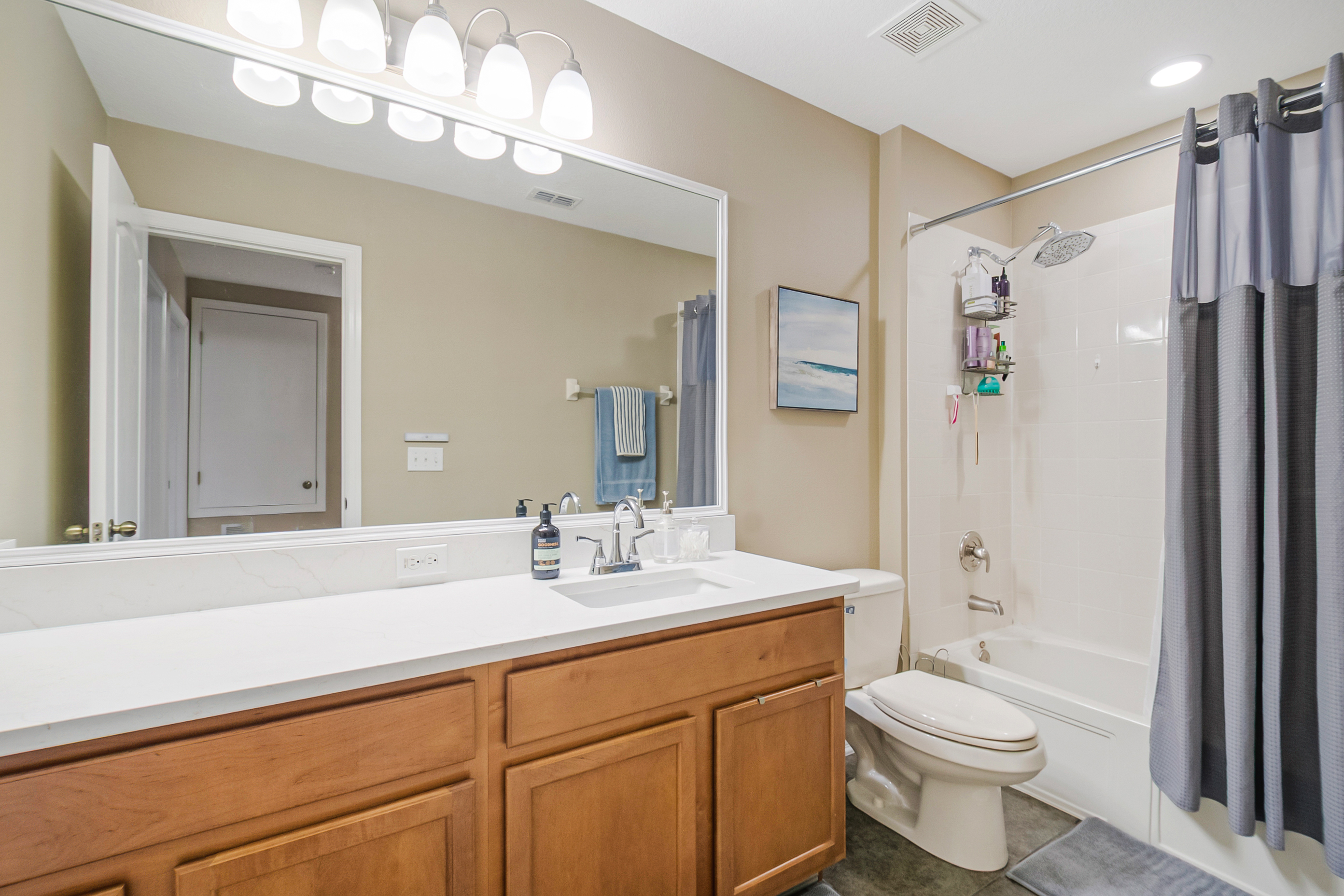 Secondary bathroom with wood vanity and tub-shower combo