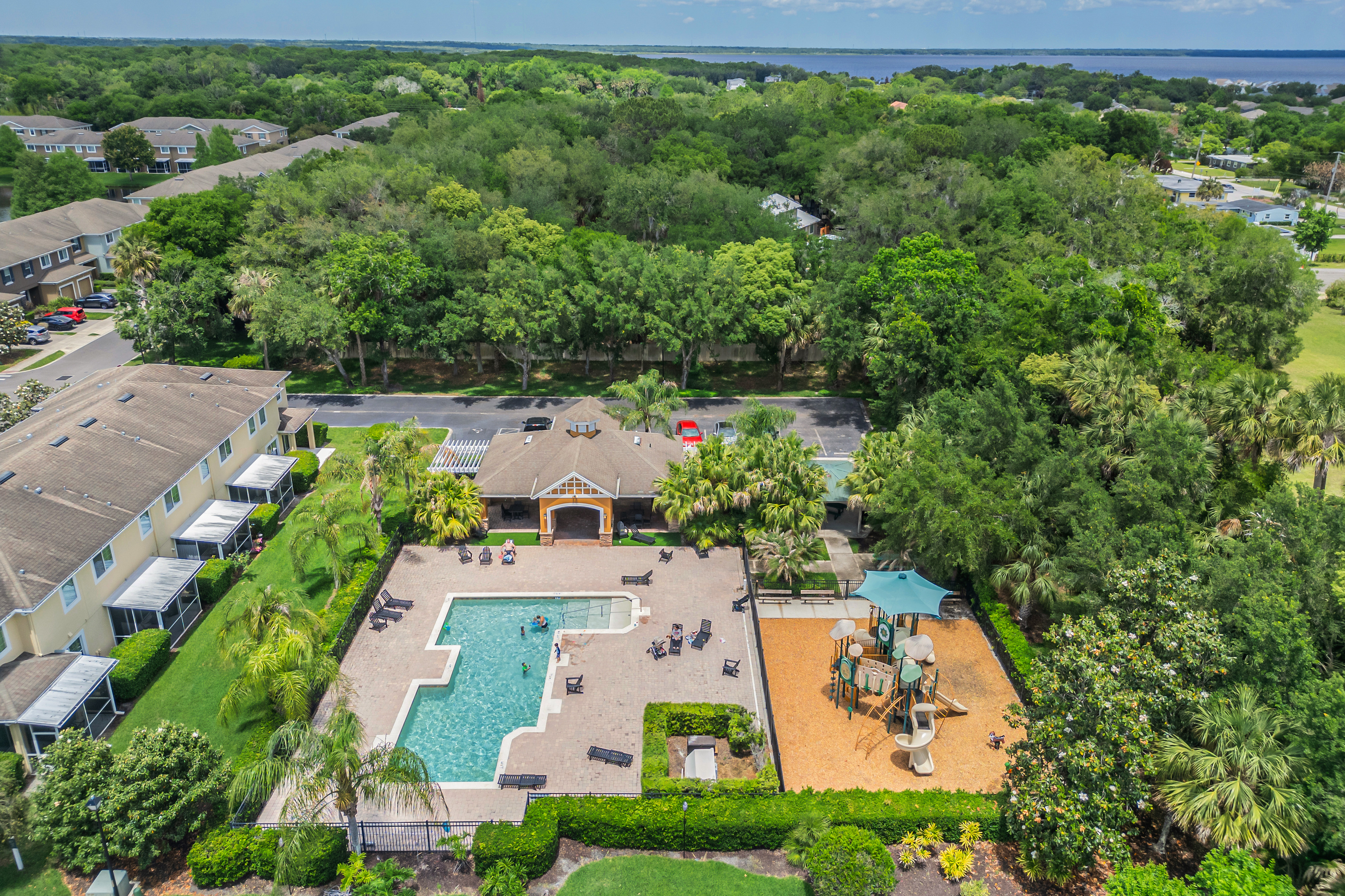 Aerial view of community pool, cabana, and playground amenities