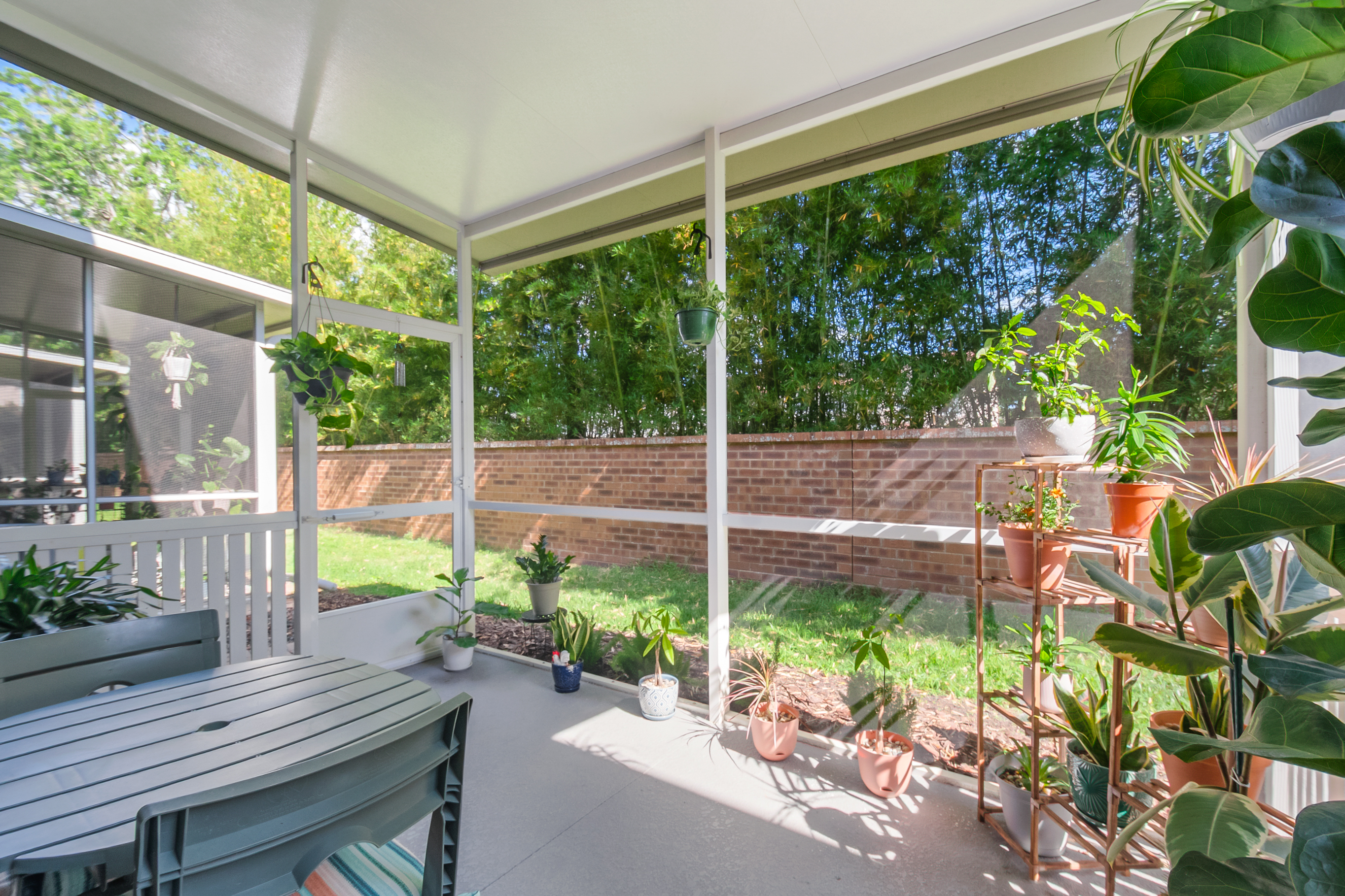 Screened-in covered porch with patio and backyard