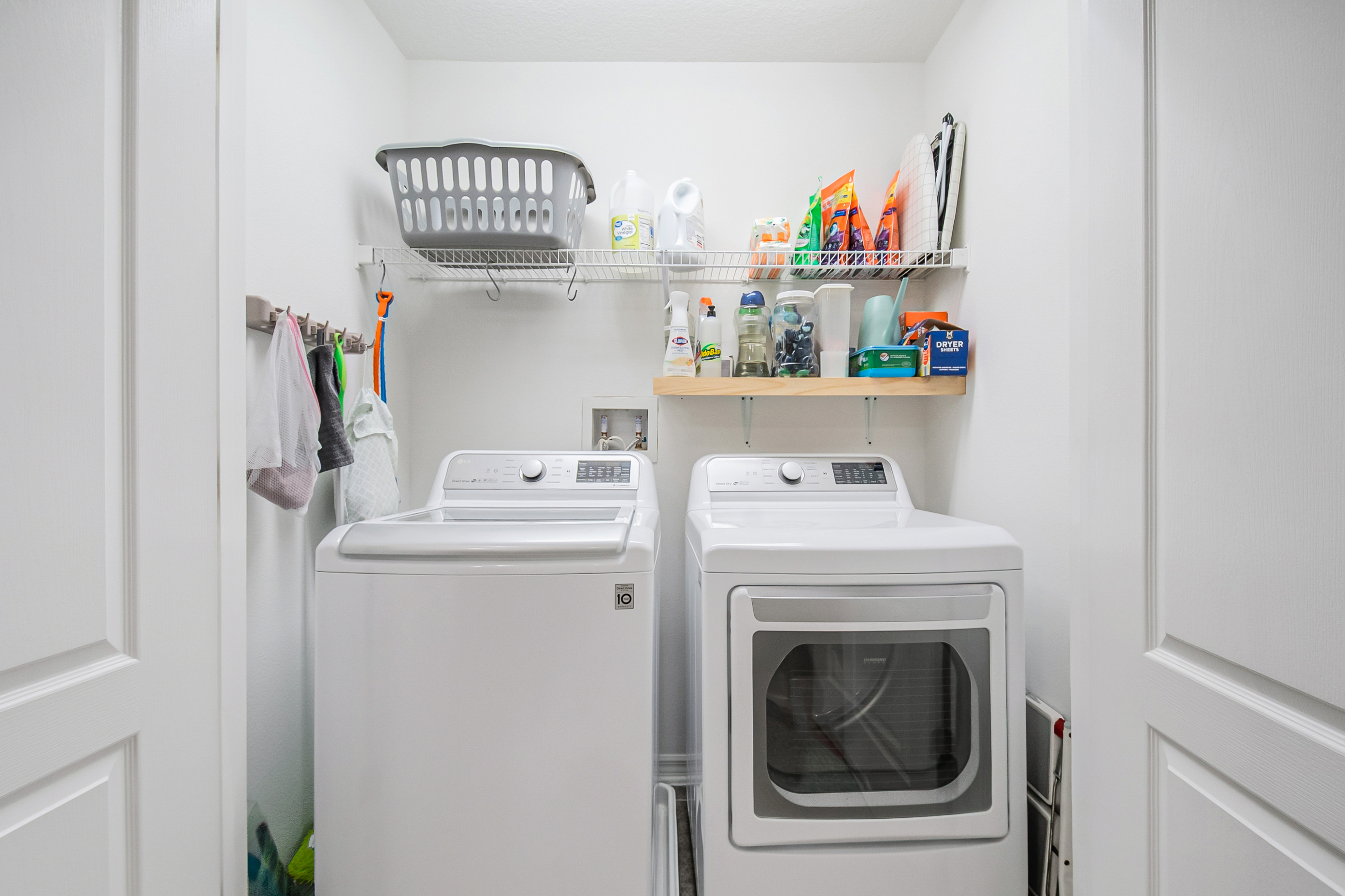 Laundry closet with wire shelving and wood accent shelf