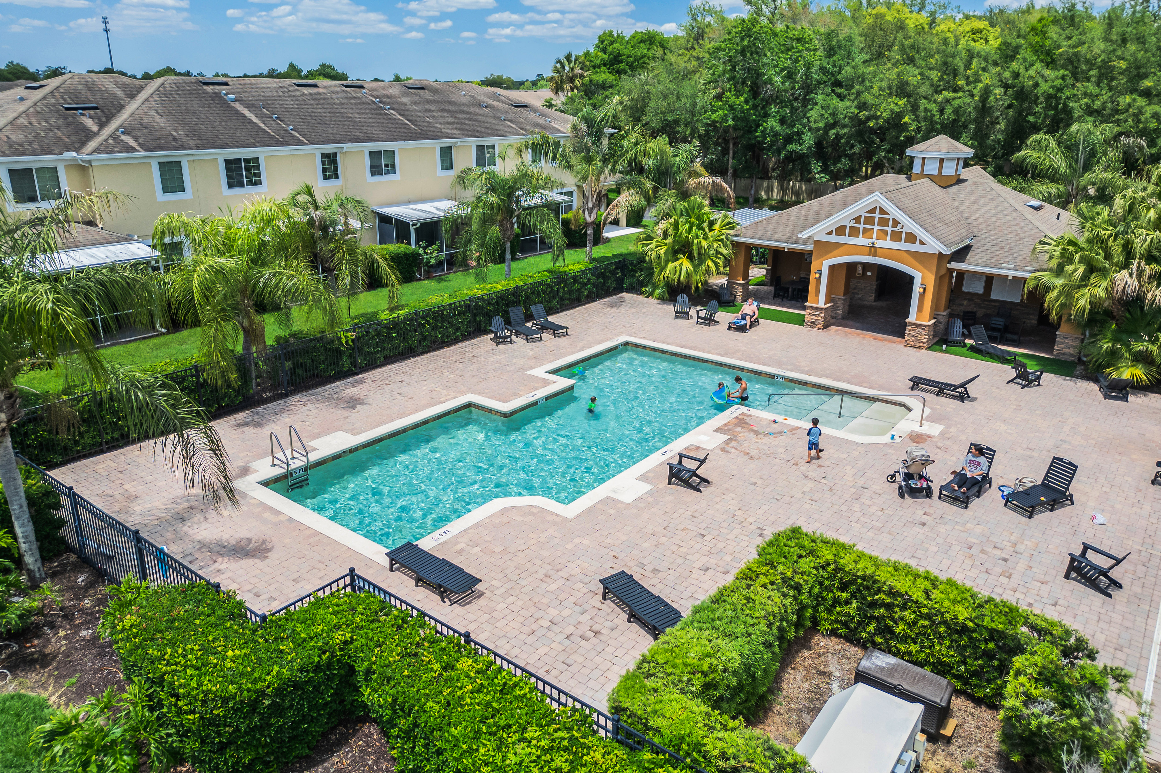 Community pool and cabana area with sun loungers