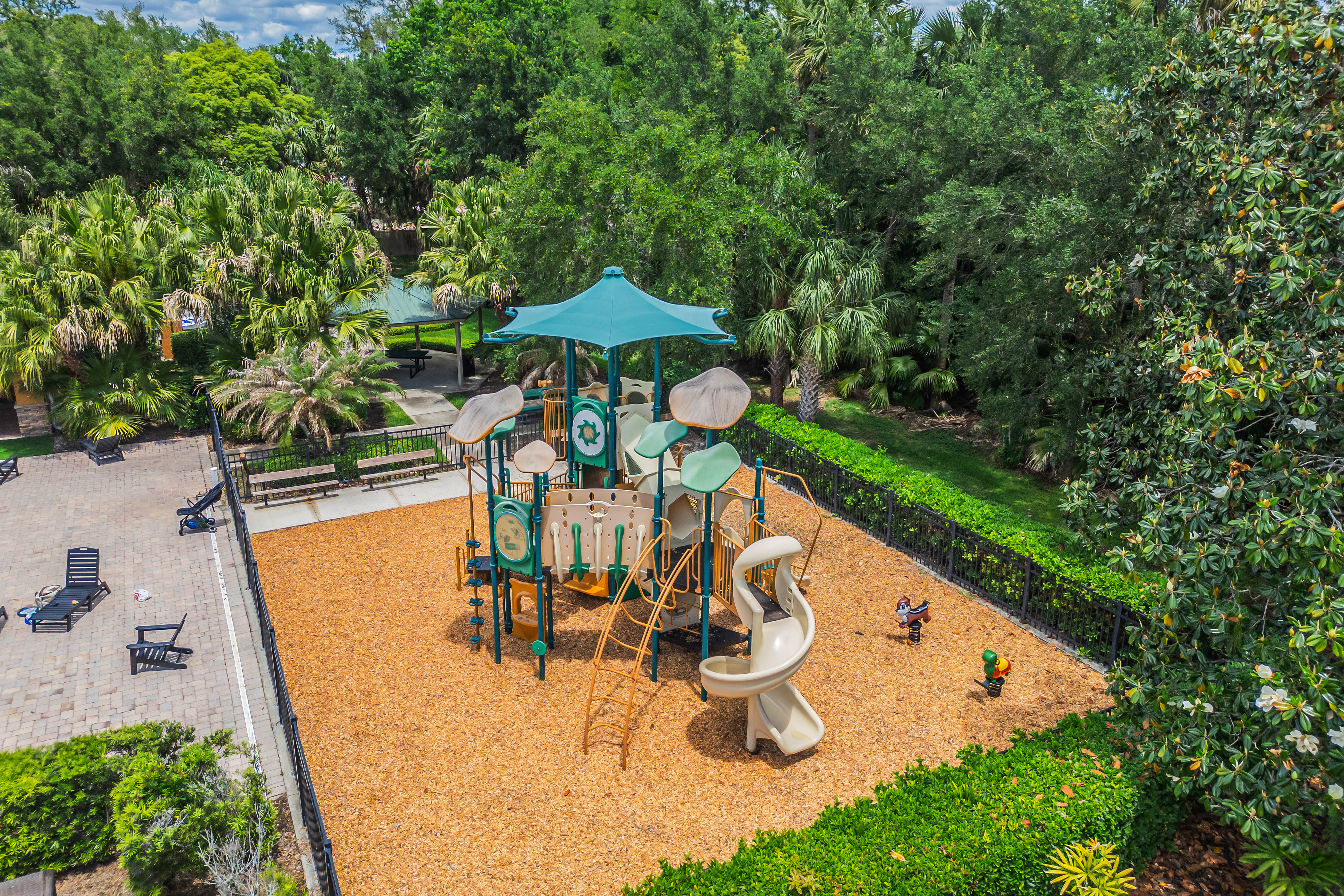 Community playground with tropical landscaping and covered pavilion