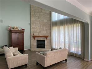Living room with stone fireplace and natural light at 6106 Peachtree Hill Court