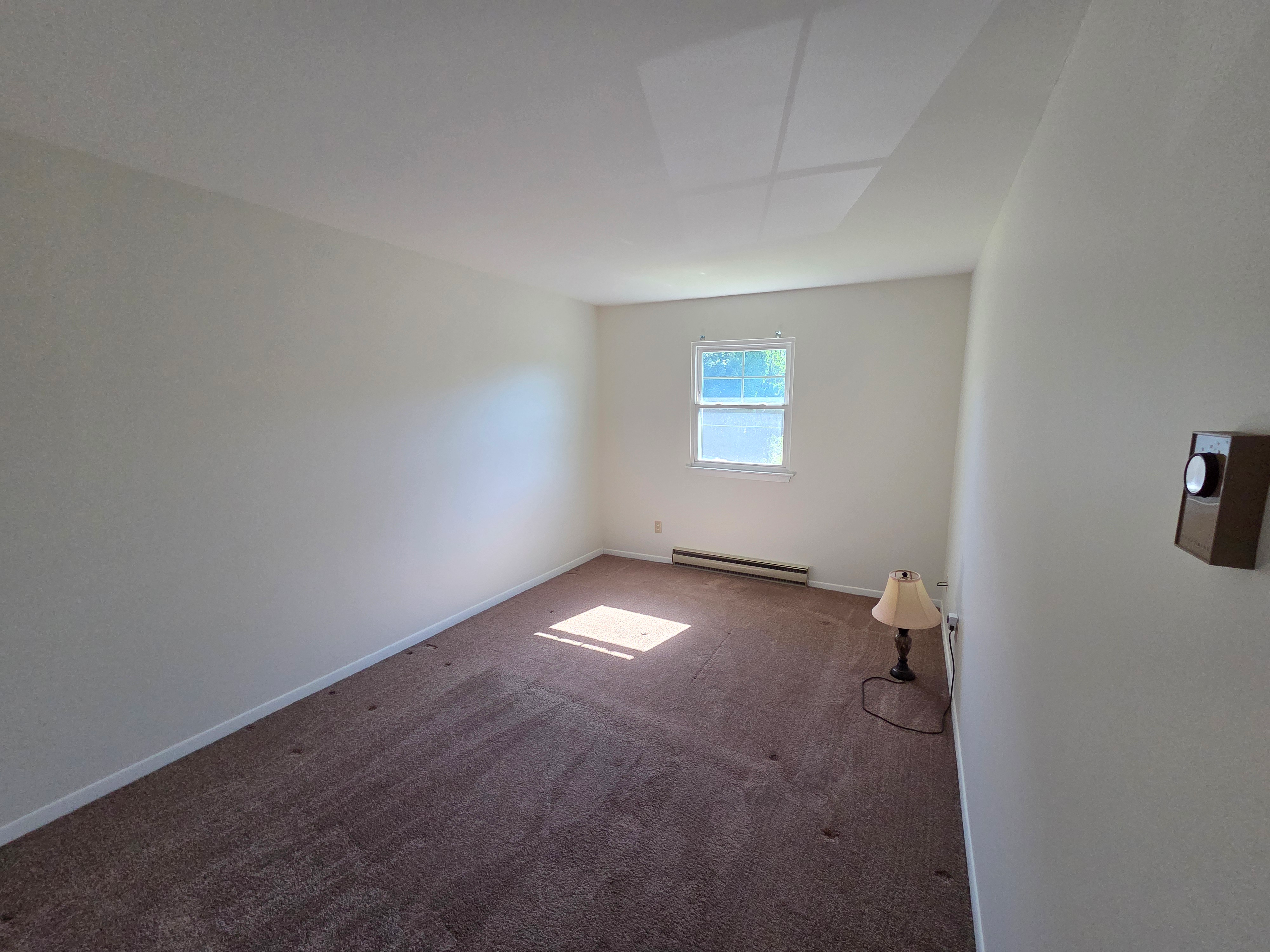 Upper level bedroom with carpeted floors, painted walls, and natural daylight from window