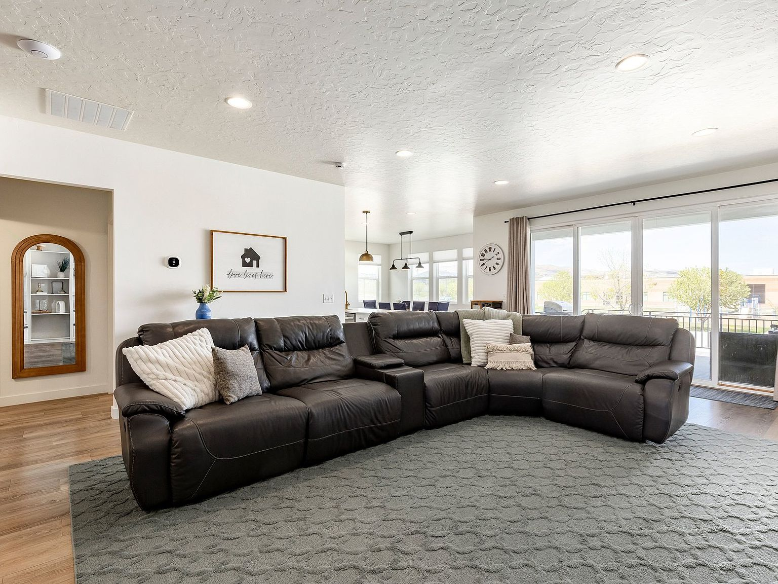 The open-concept living room, filled with natural light from the rear glass doors