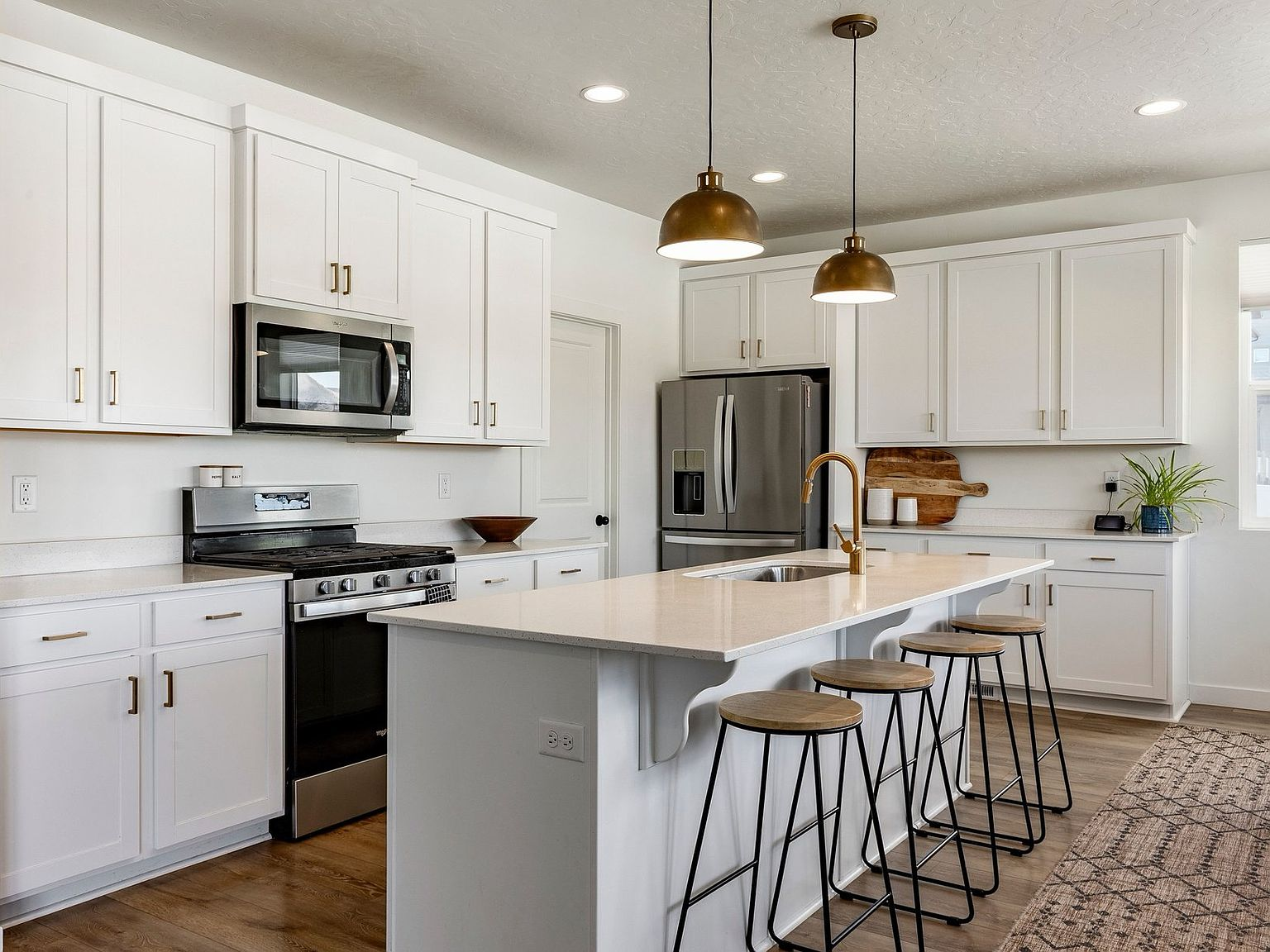 The kitchen island beneath warm brass pendant lights