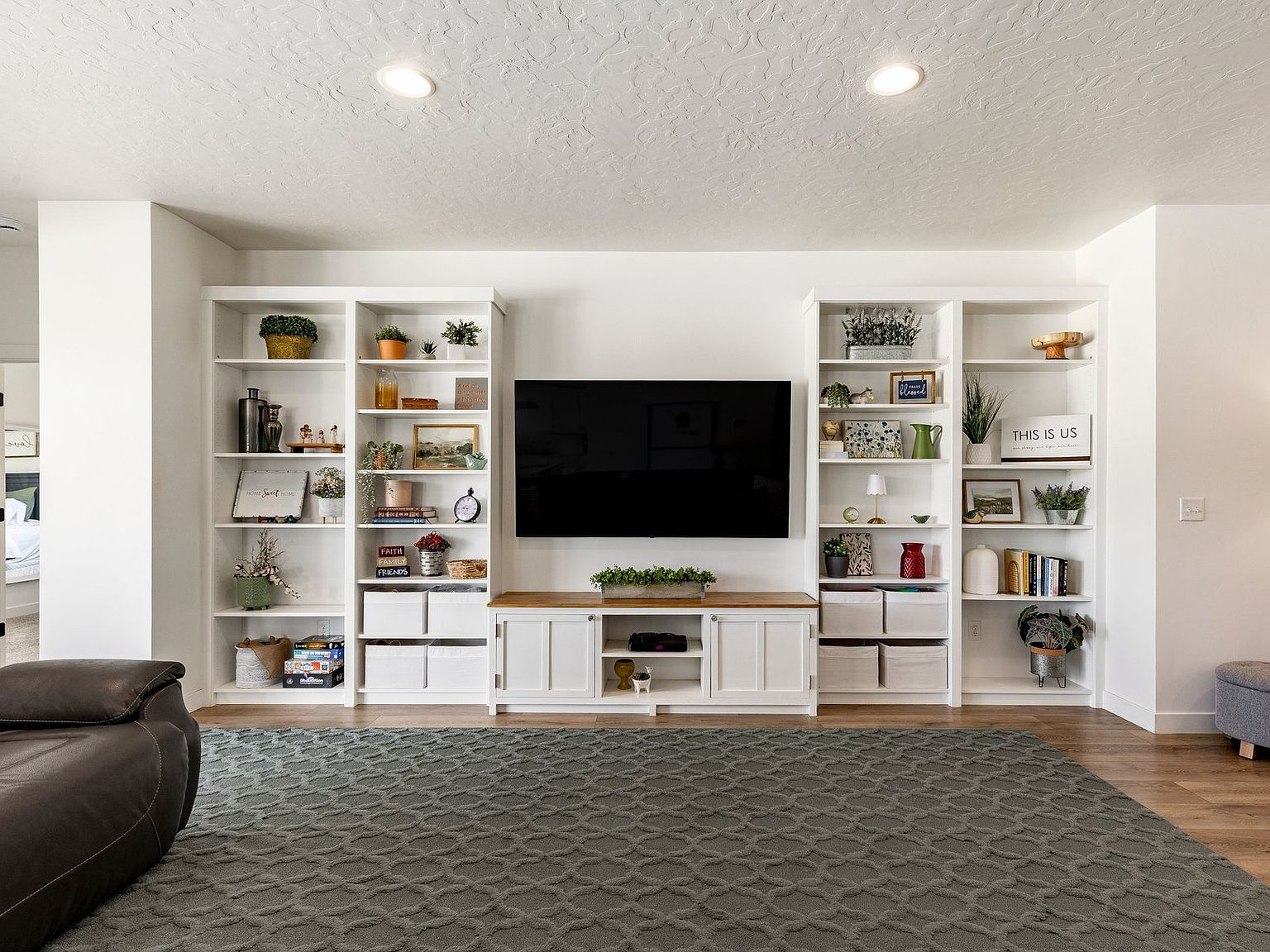 The living room's custom built-in shelving and feature wall
