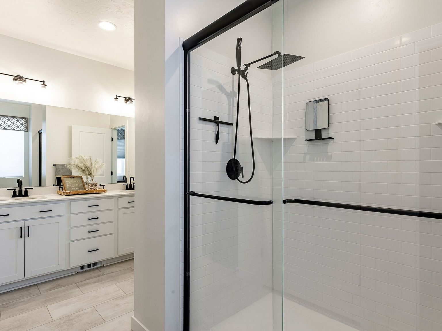 The primary bath with its glass shower and dual vanity