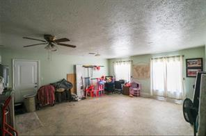 A converted garage flex room in a Northeast Houston home with concrete floors and windows, the kind of space buyers turn into a garage apartment or in-law suite