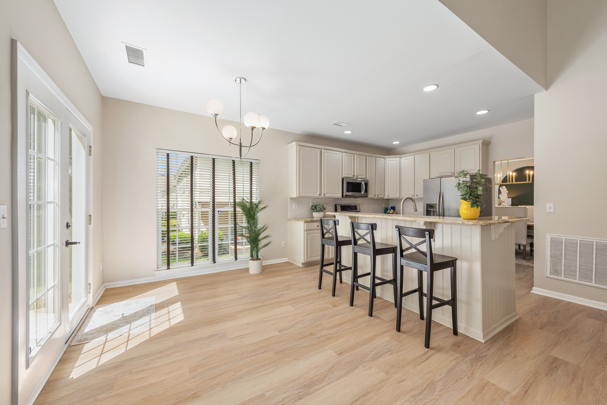 Open-concept kitchen and dining area with shaker cabinets and granite countertops