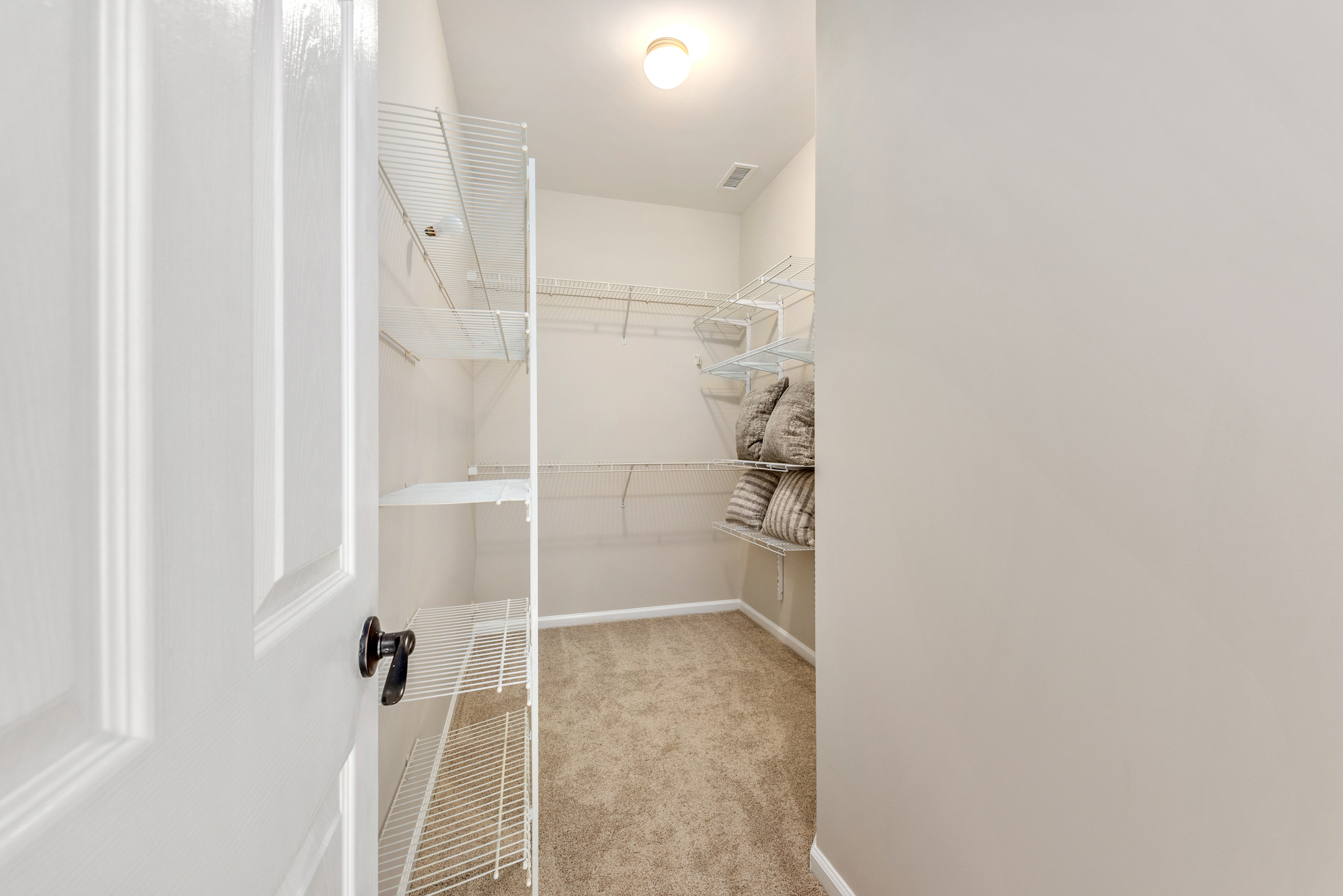 Primary bedroom walk-in closet with white wire shelving
