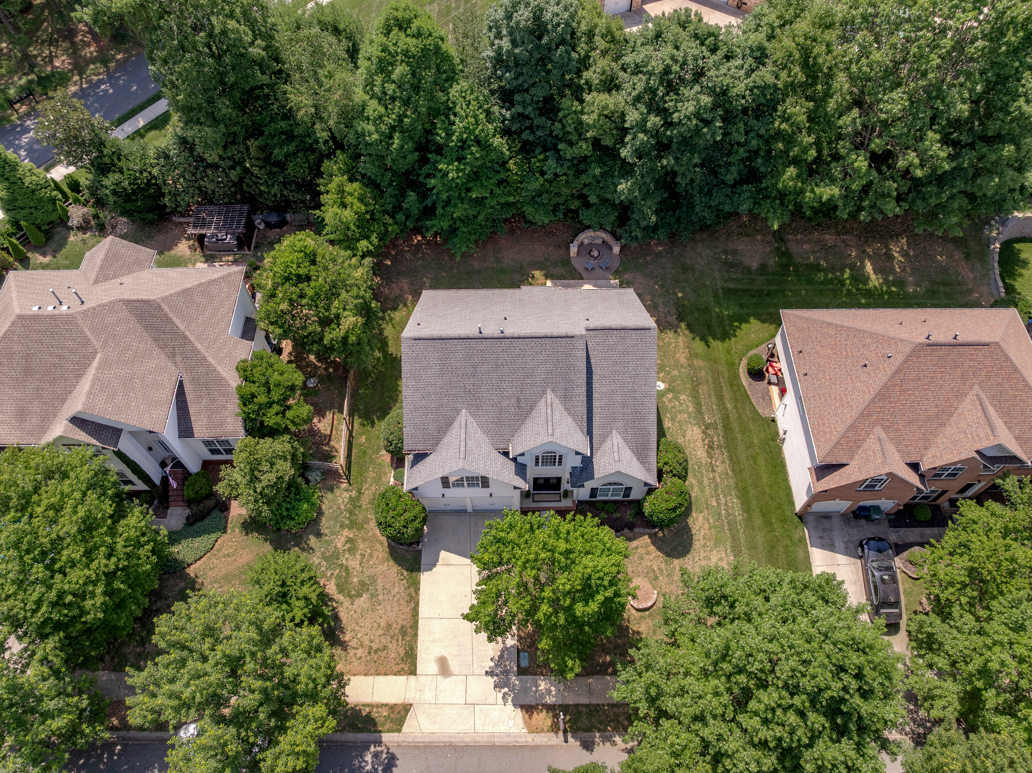 High-angle drone view showing the property lot, driveway, and landscaping
