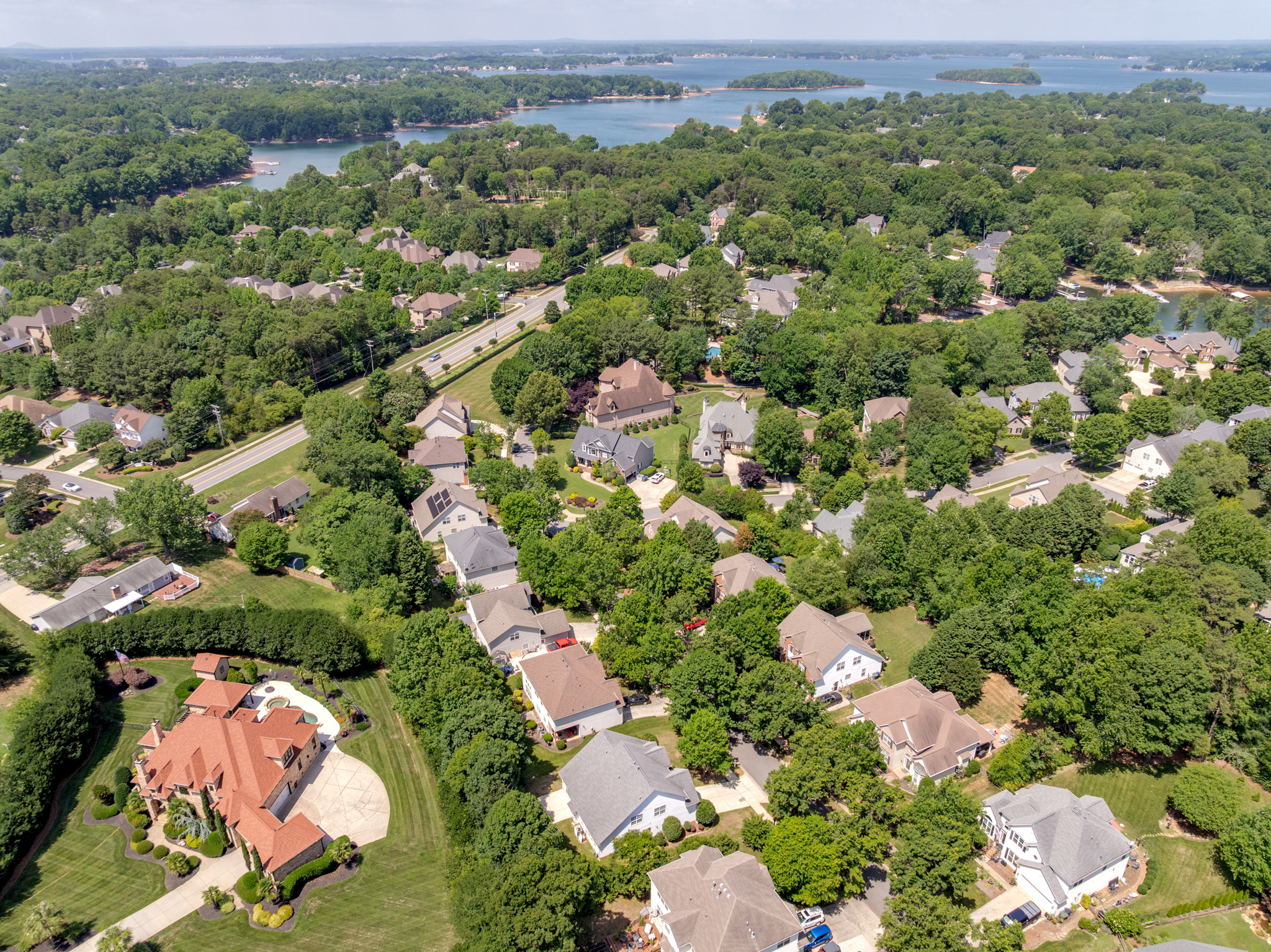 Aerial view of neighborhood near Lake Norman with tree canopy and residential rooflines
