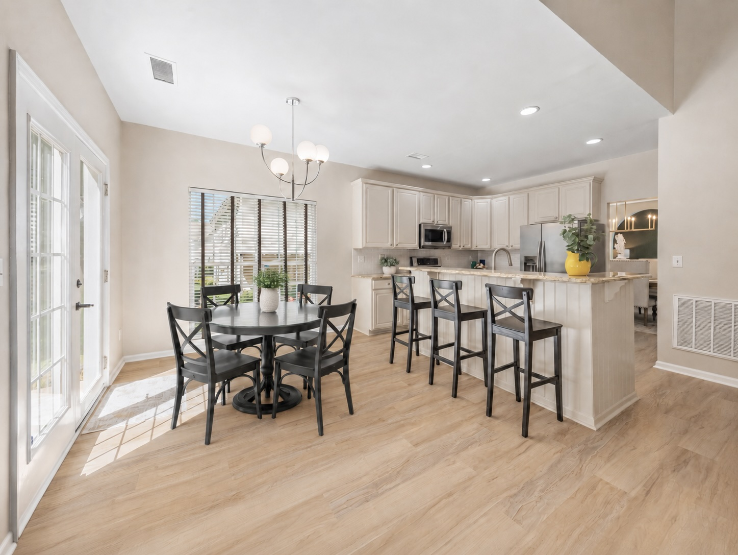 Kitchen-adjacent dining area with natural light from glass double doors