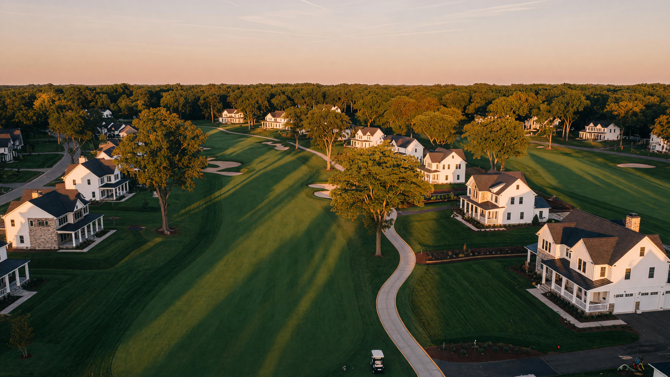 Aerial view of a Michigan golf course community with mature trees and fairway greens