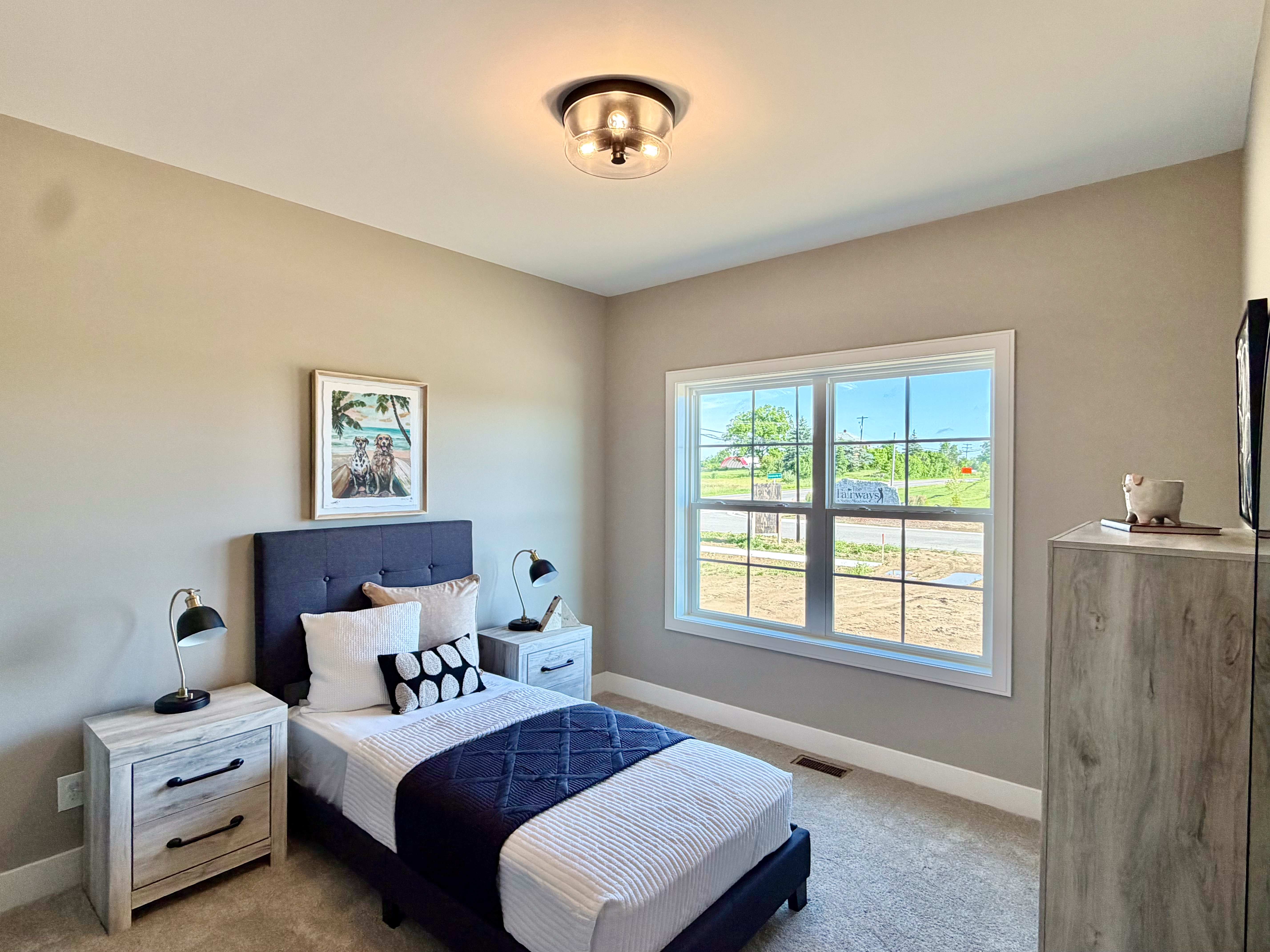 Secondary bedroom with light wood furniture and neutral palette