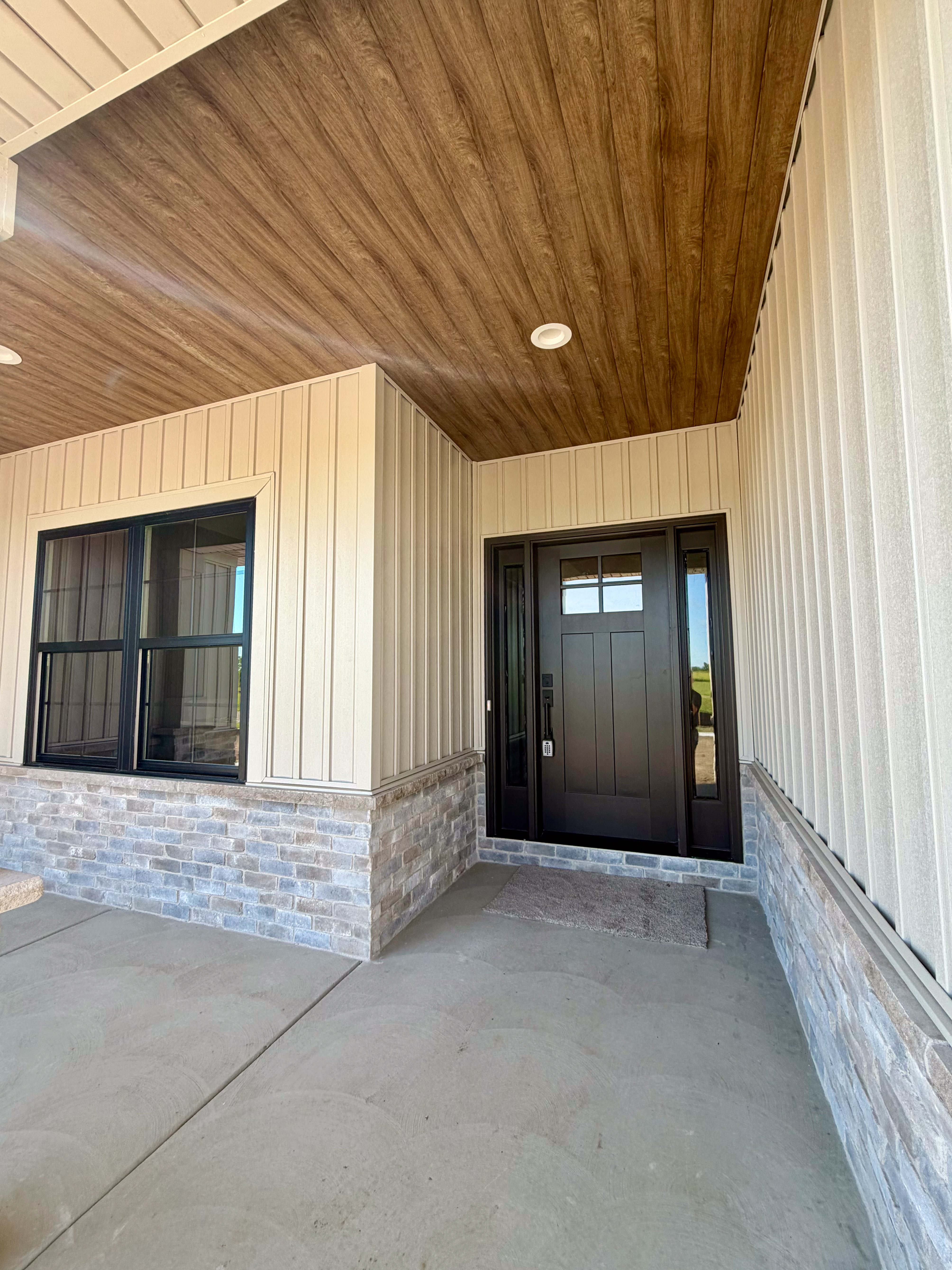 Front entryway with dark-stained door and glass transom