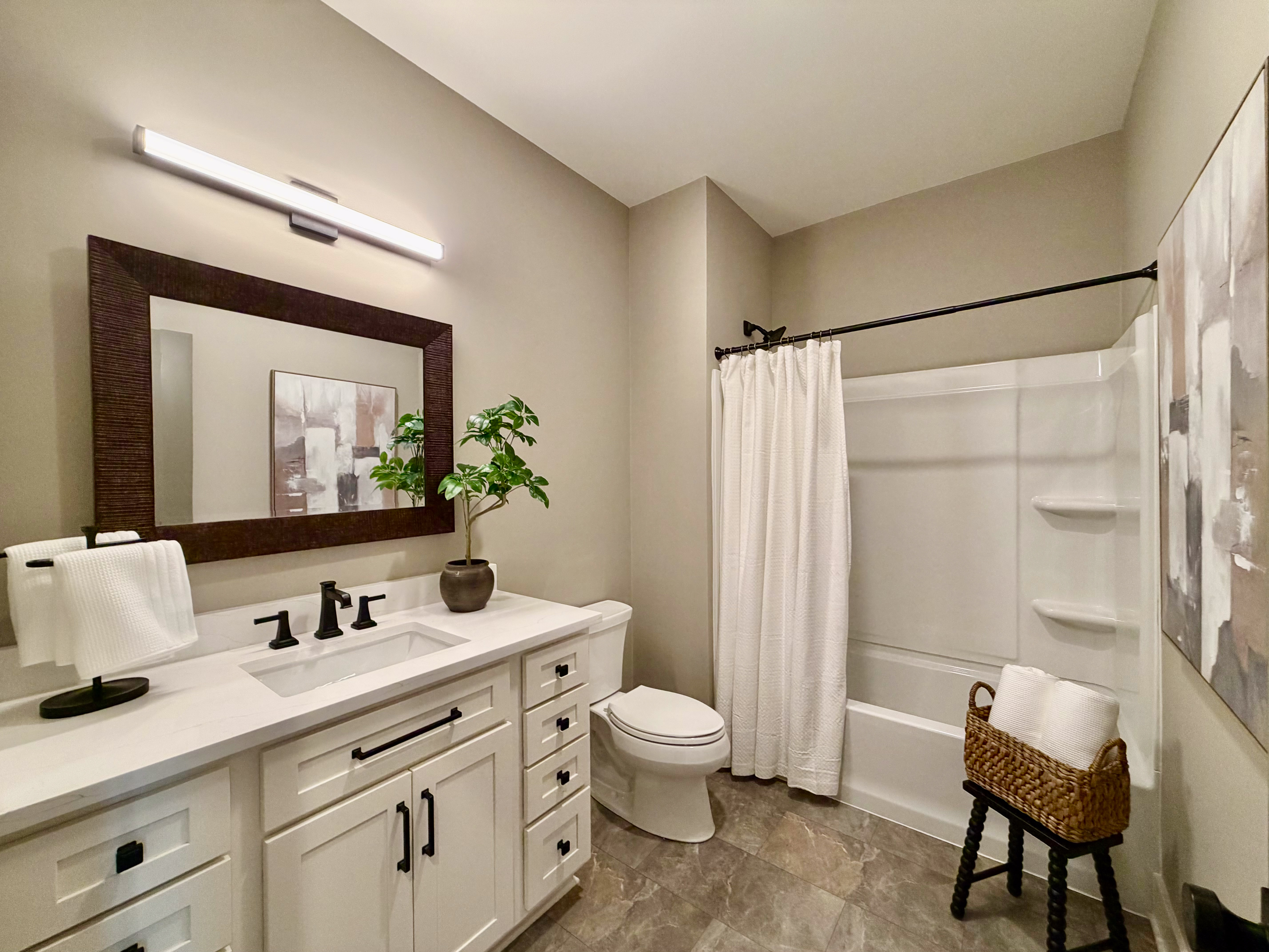 Secondary bathroom with white shaker vanity and oil-rubbed bronze fixtures