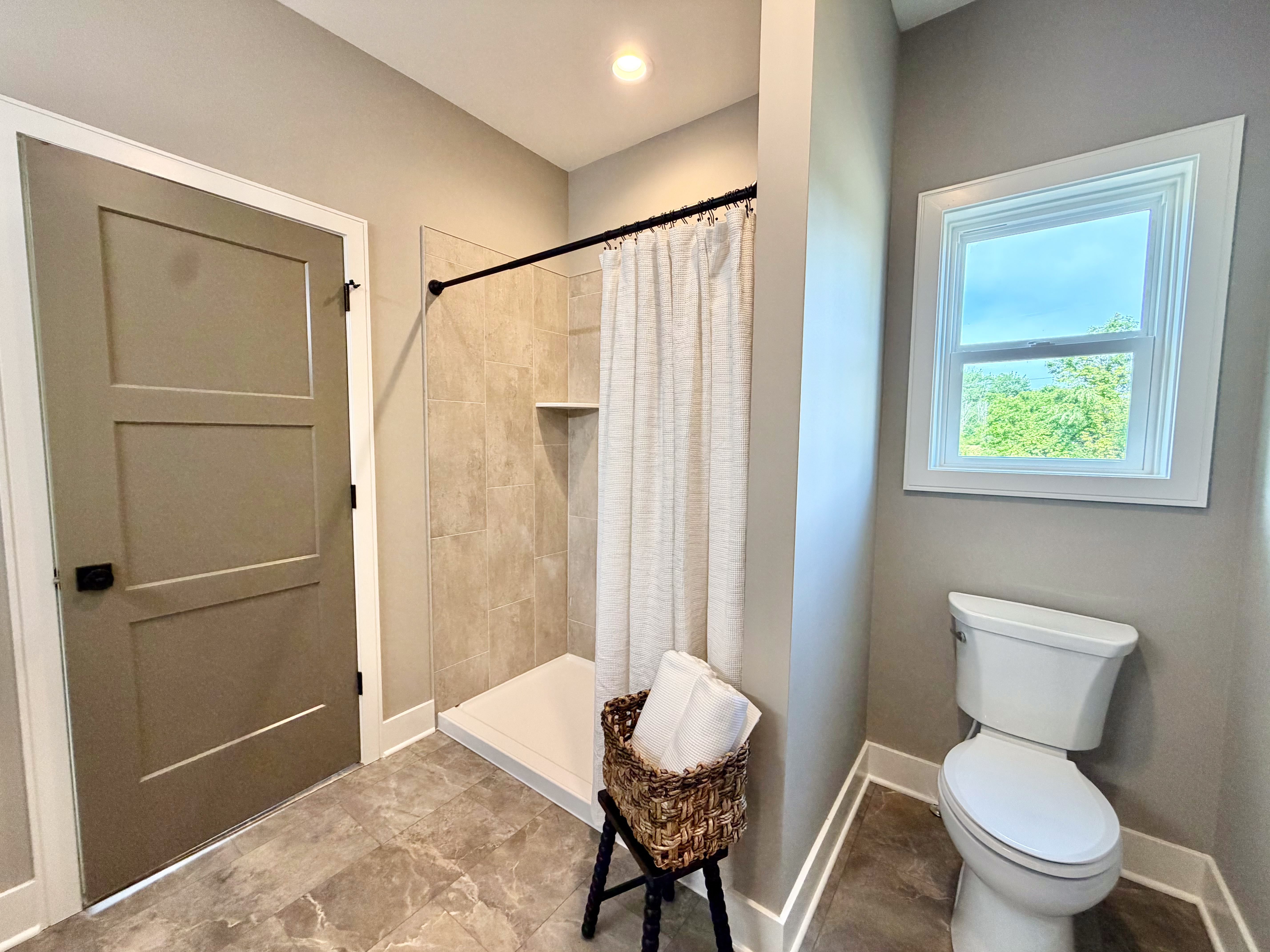 Tile shower surround with recessed lighting and porcelain floor