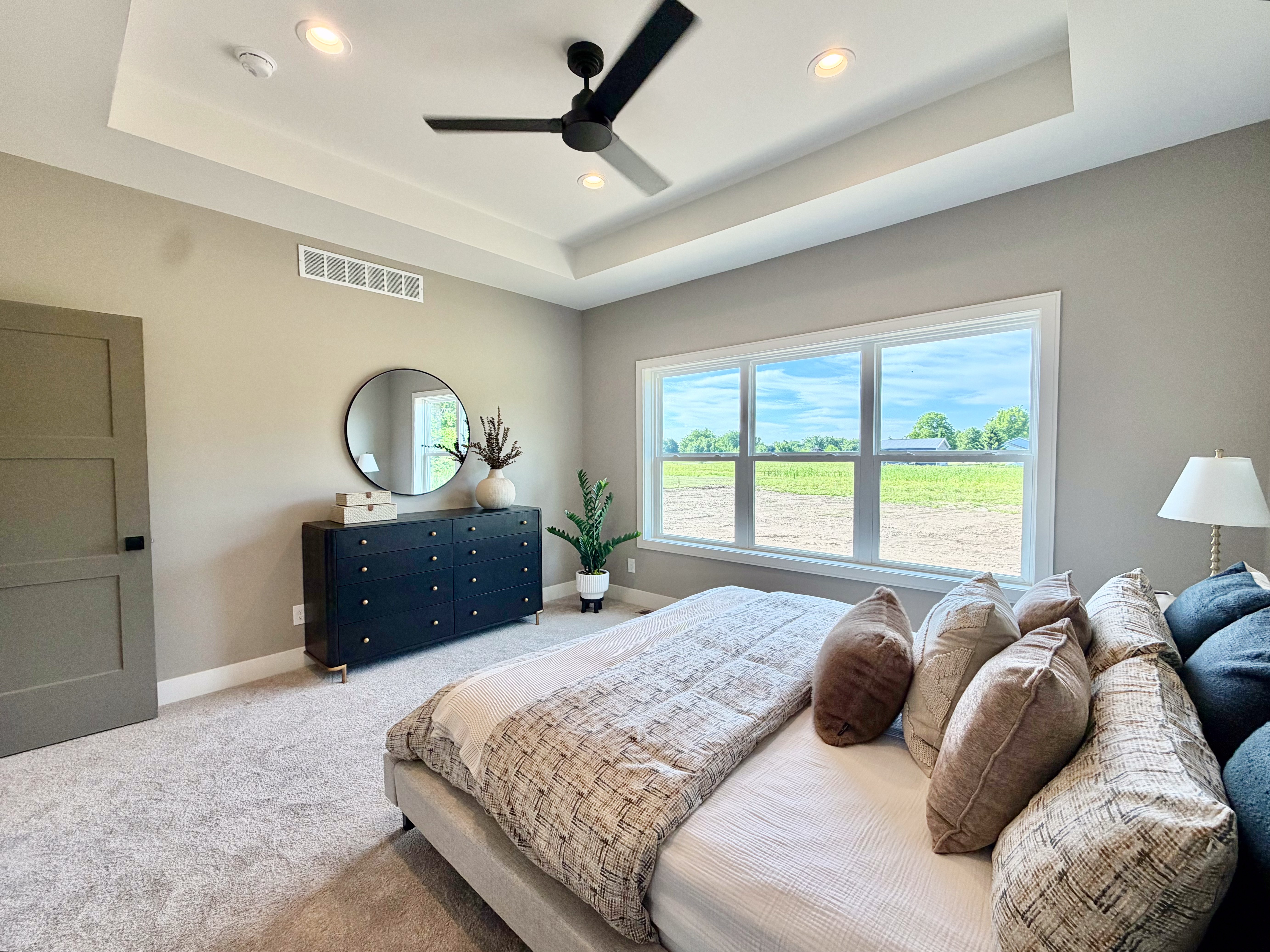 Master bedroom with trey ceiling, neutral palette, and expansive windows