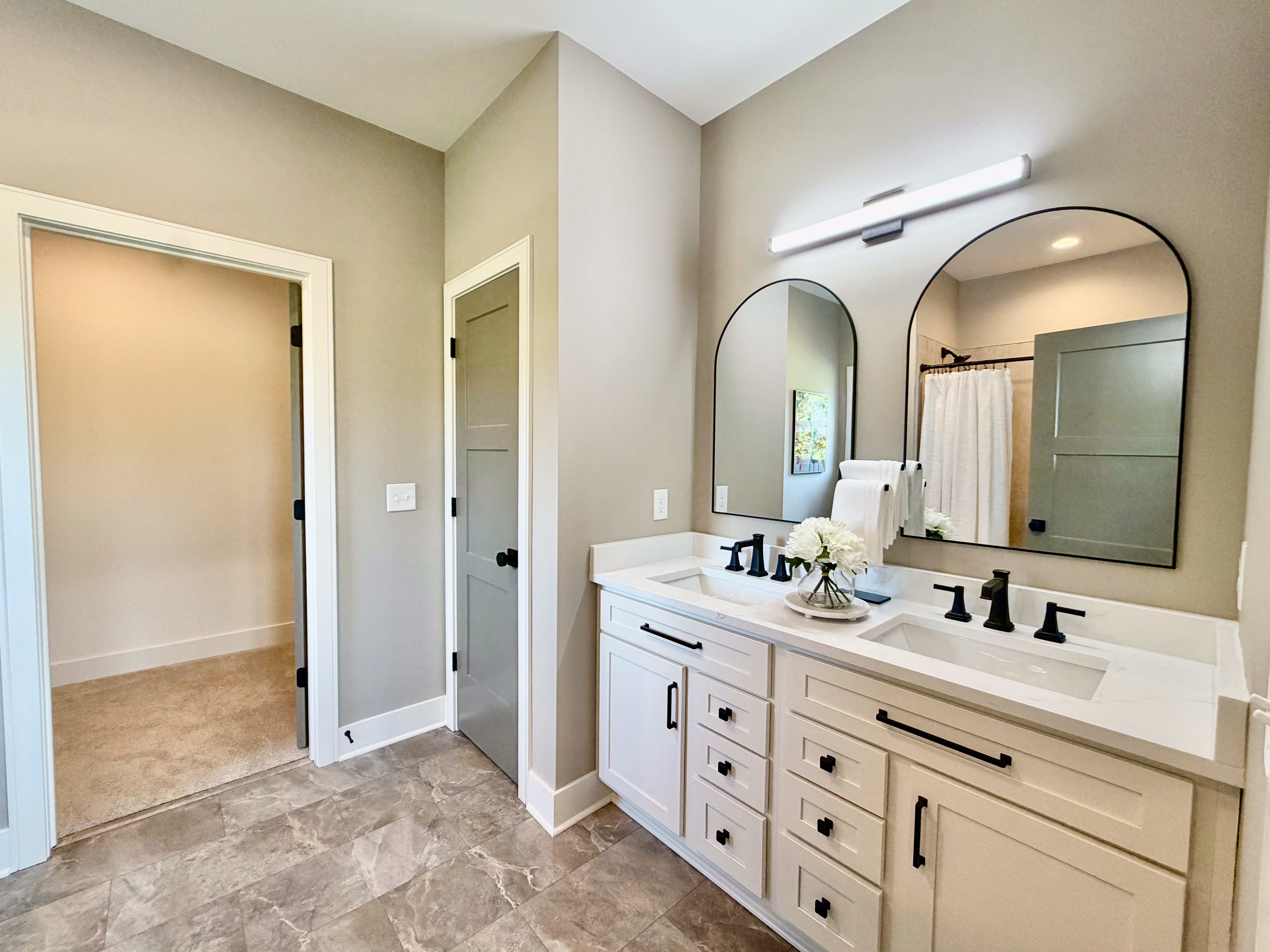 Bathroom with double vanity, quartz countertop, and matte black fixtures