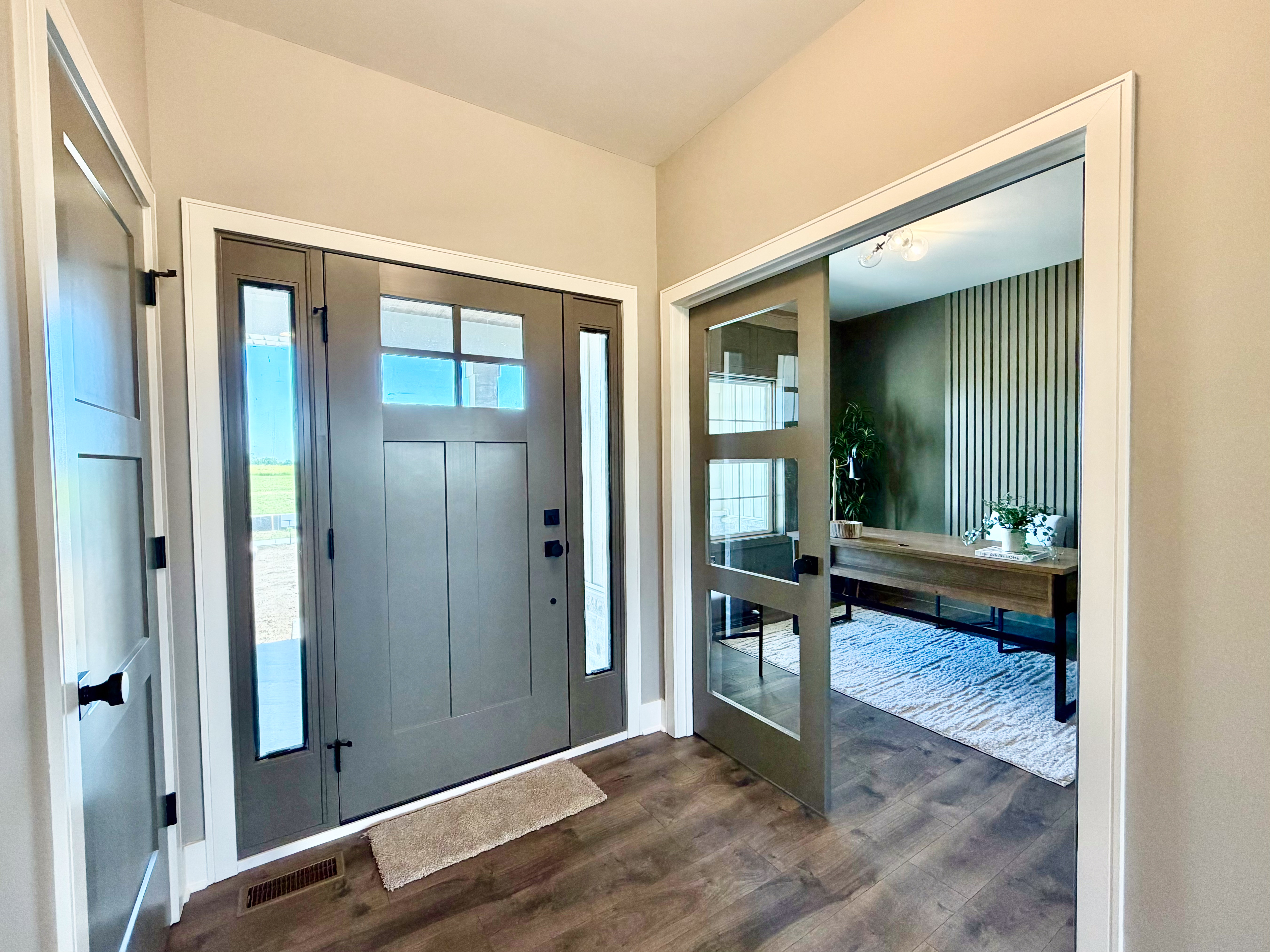 Foyer looking toward front entrance and glass-paneled office door
