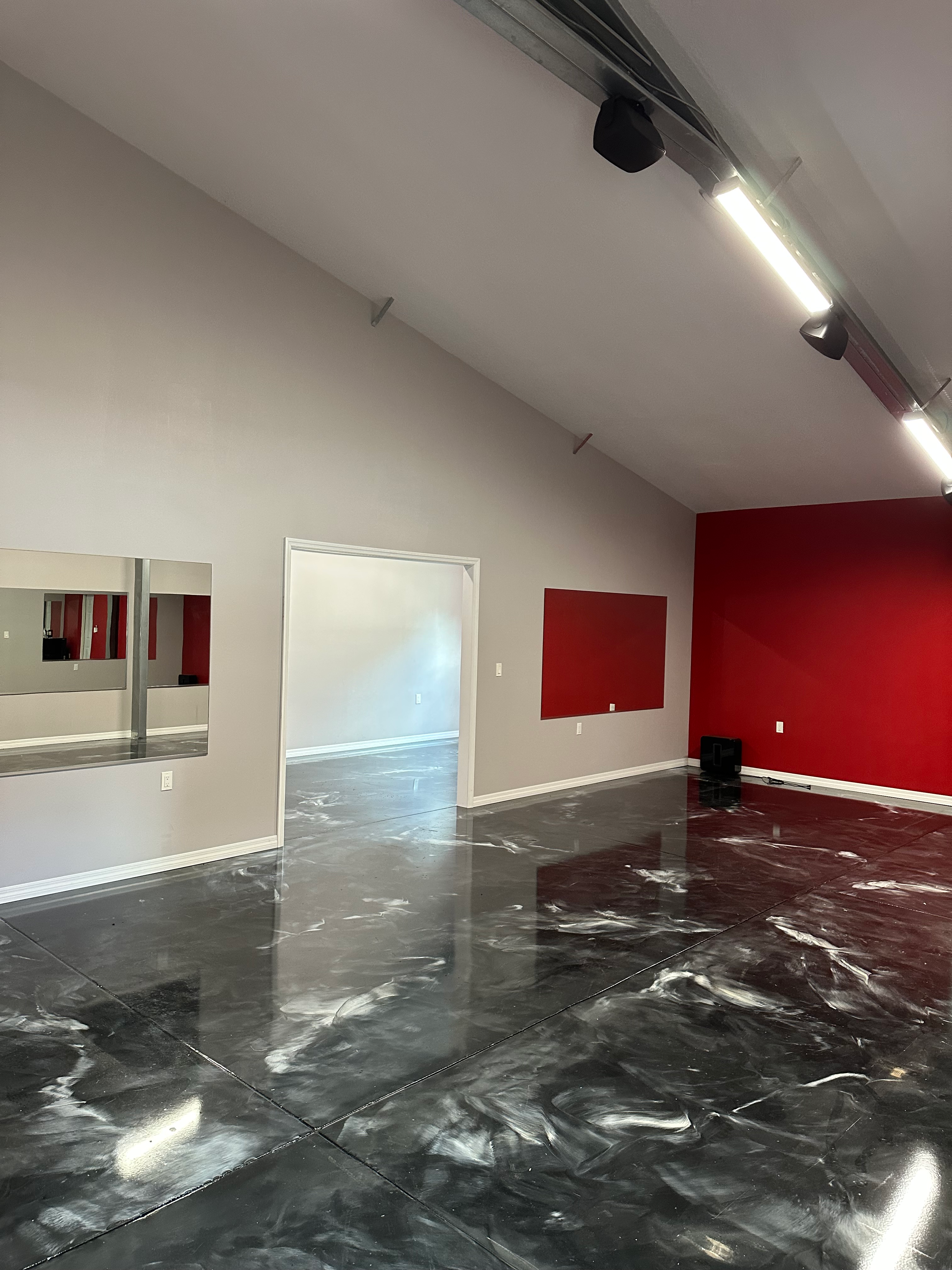 Fitness-ready flex space with mirrors and high-intensity track lighting