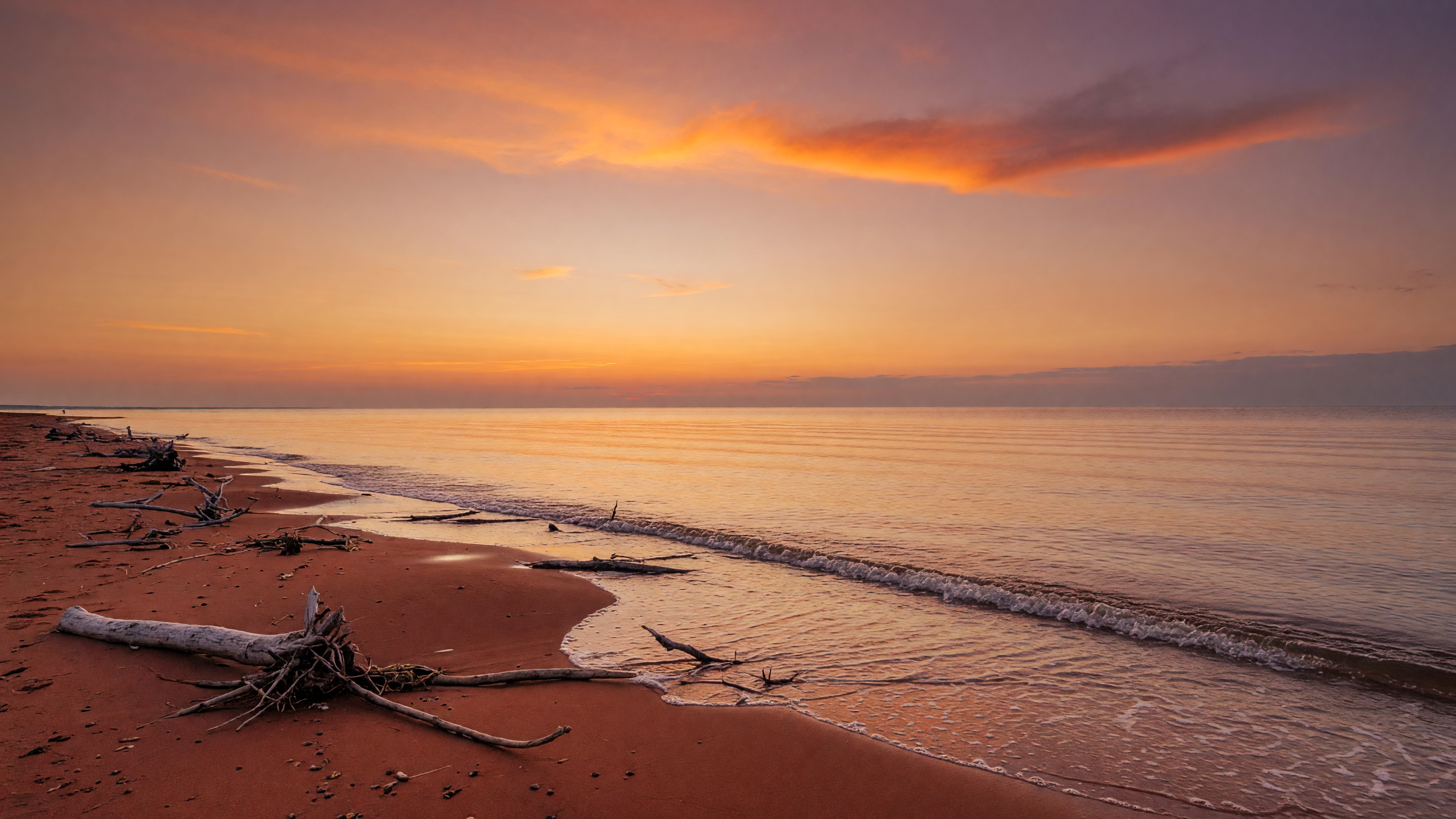 PEI beach at sunset with gentle waves and red sand