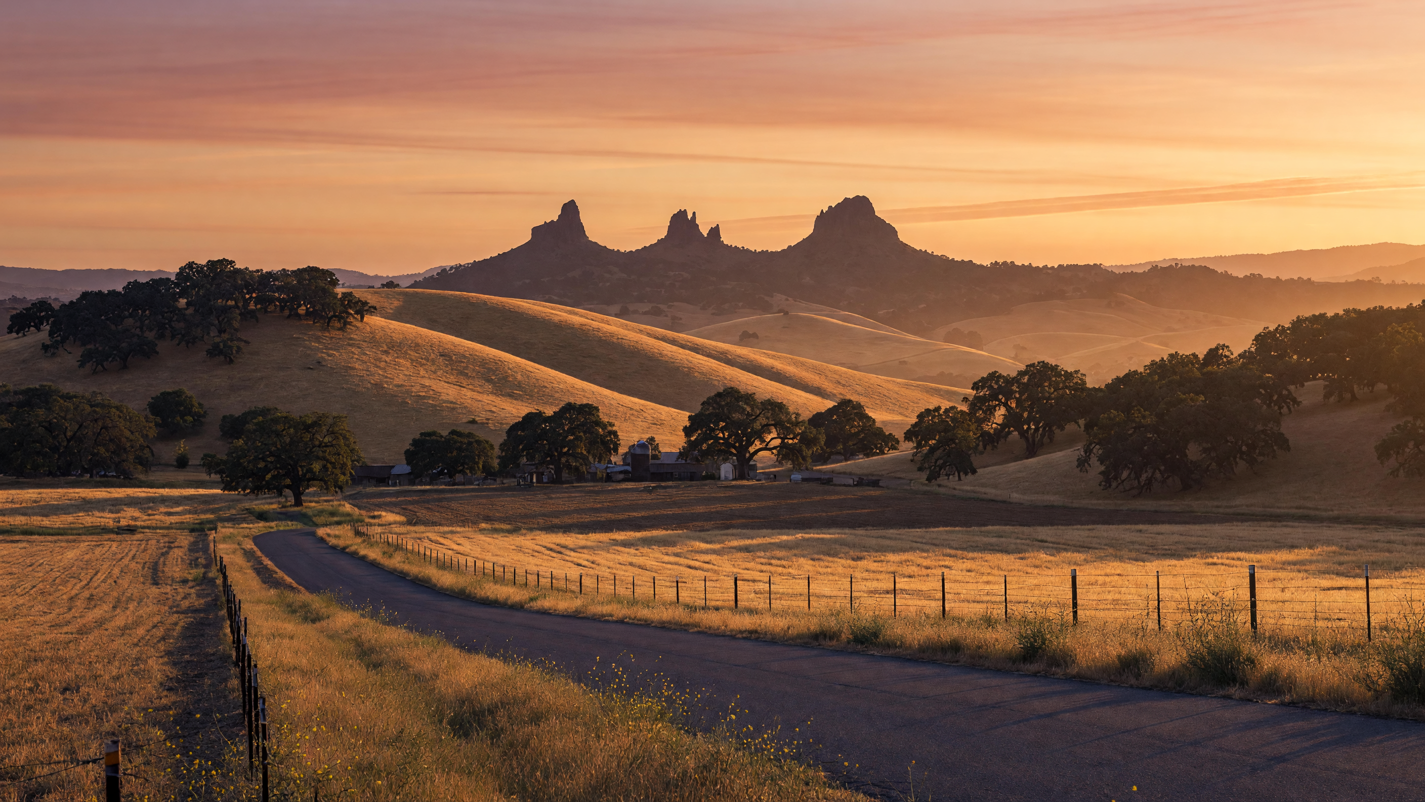 Golden hour landscape of Northern California near Beale Air Force Base — rolling hills, live oaks, and the Sutter Buttes