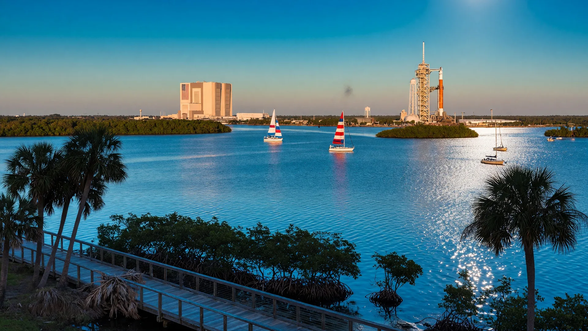 Palm Bay's Space Coast setting with the Indian River Lagoon, Kennedy Space Center launch towers visible in the distance, and palm trees along the shoreline