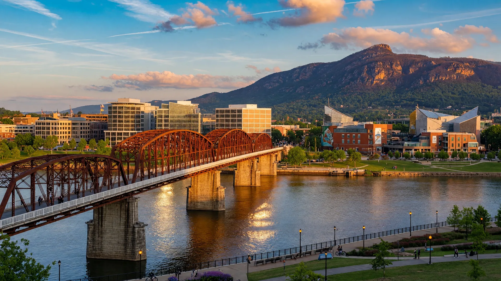 Chattanooga Tennessee's iconic Walnut Street Bridge spanning the Tennessee River with Lookout Mountain in the background and the revitalized downtown skyline