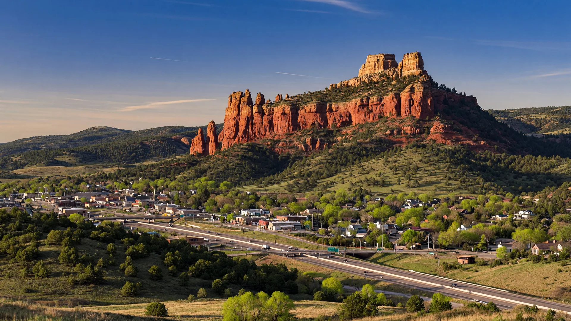 Castle Rock's distinctive butte rock formation overlooking the town — the castle-shaped landmark against a clear Colorado sky with rolling hills and pine trees
