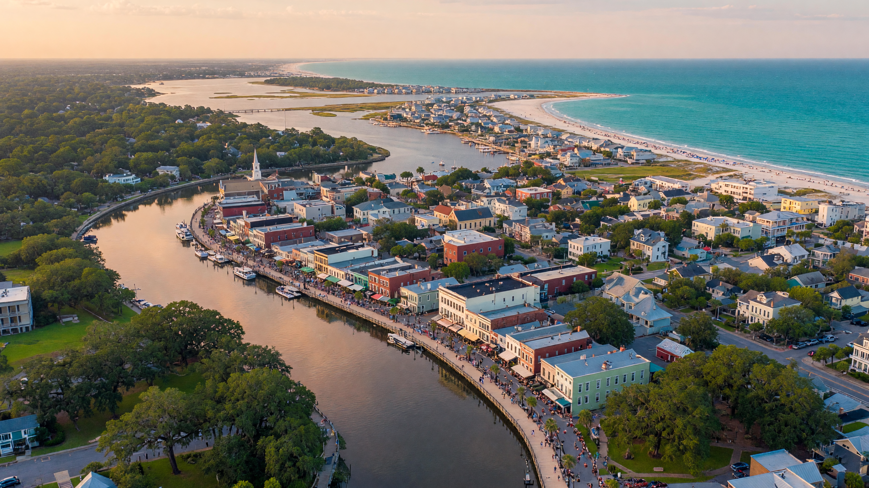 Aerial view of Wilmington, North Carolina showing the Cape Fear River winding through the historic downtown with barrier island beaches in the distance