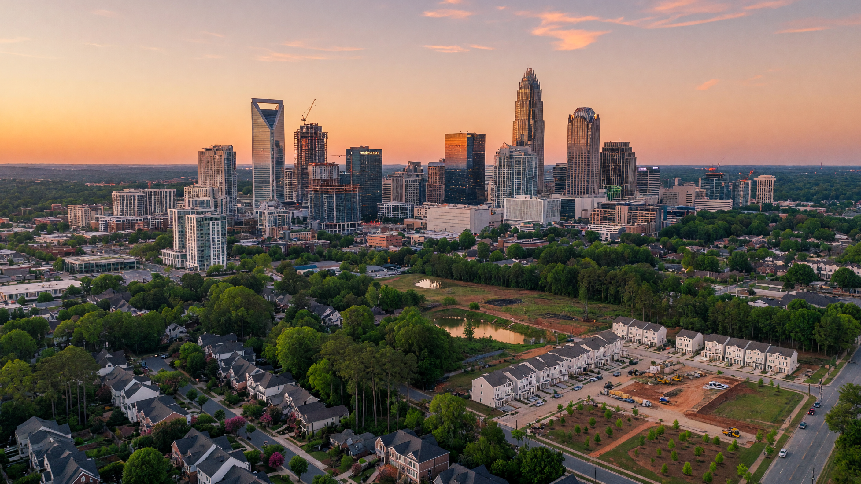 Charlotte North Carolina skyline at golden hour with Uptown skyscrapers and tree-lined neighborhoods