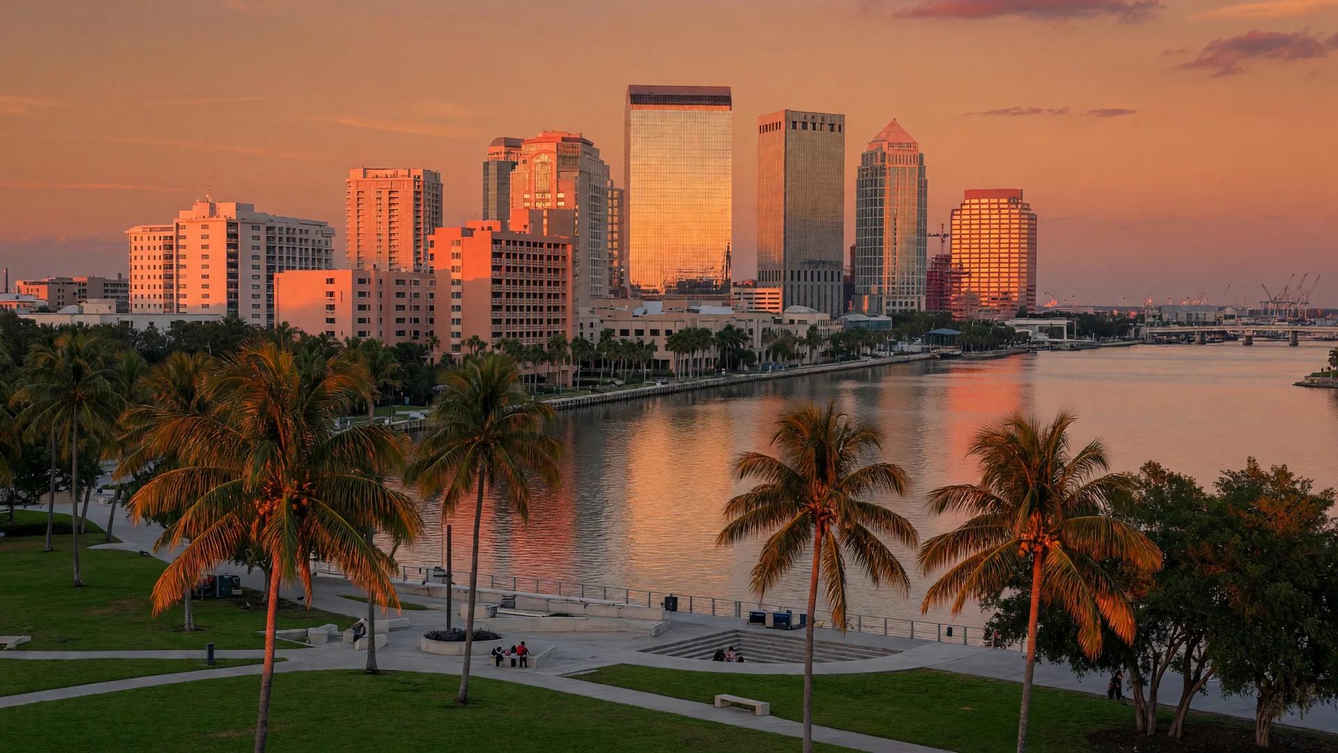 Downtown Tampa skyline along the Hillsborough River with Curtis Hixon Park and palm trees at golden hour
