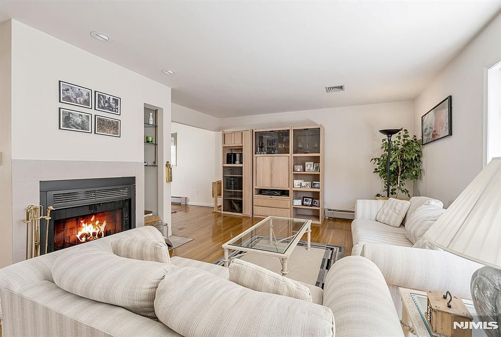 Living room with wood-burning fireplace, tiled surround, and recessed lighting