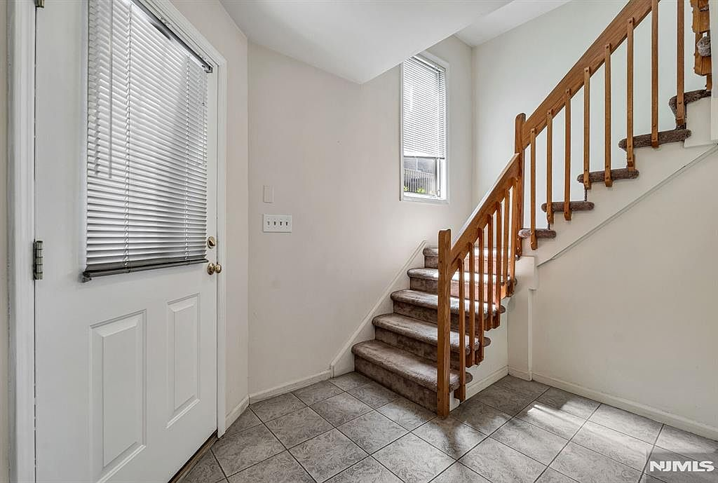 Entry foyer with tiled floor and staircase