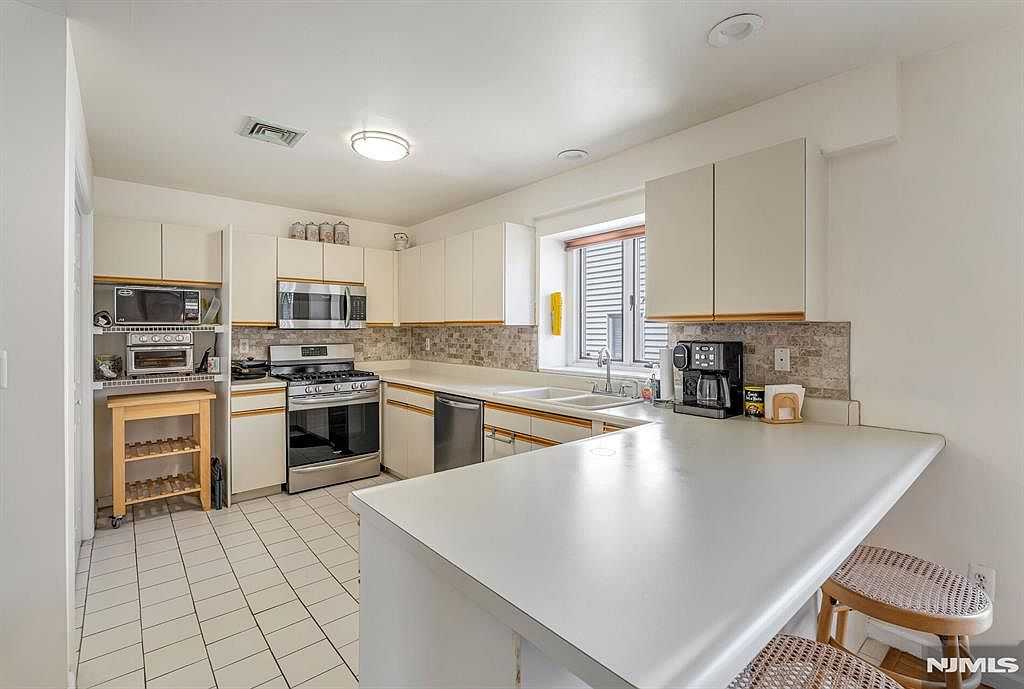 Kitchen with peninsula counter and ceramic tile backsplash