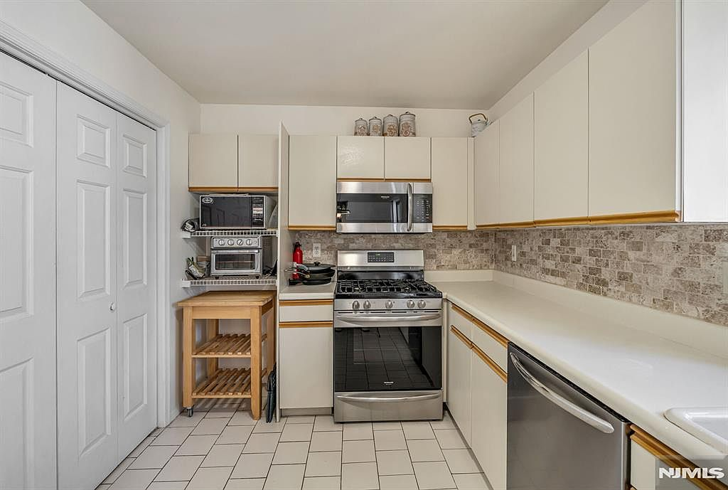 Kitchen view toward stove with stainless steel appliances