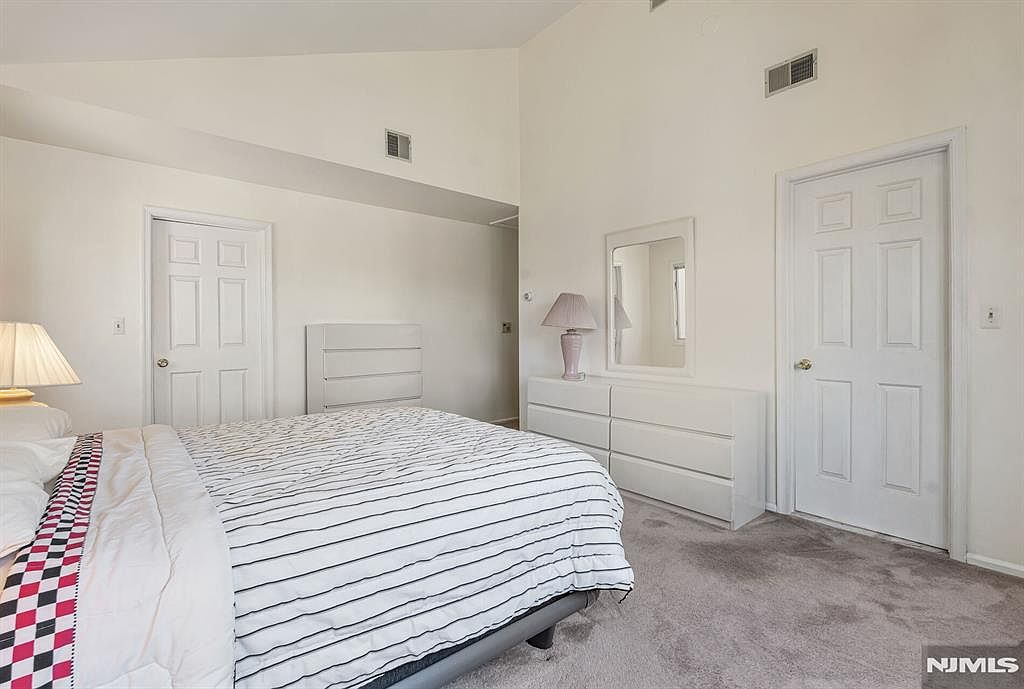 Primary bedroom with vaulted ceilings and natural light