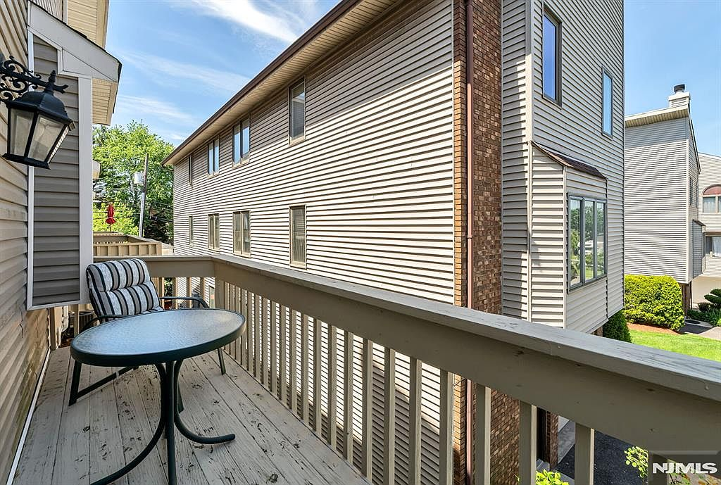 West-facing wood deck with railing overlooking common lawn